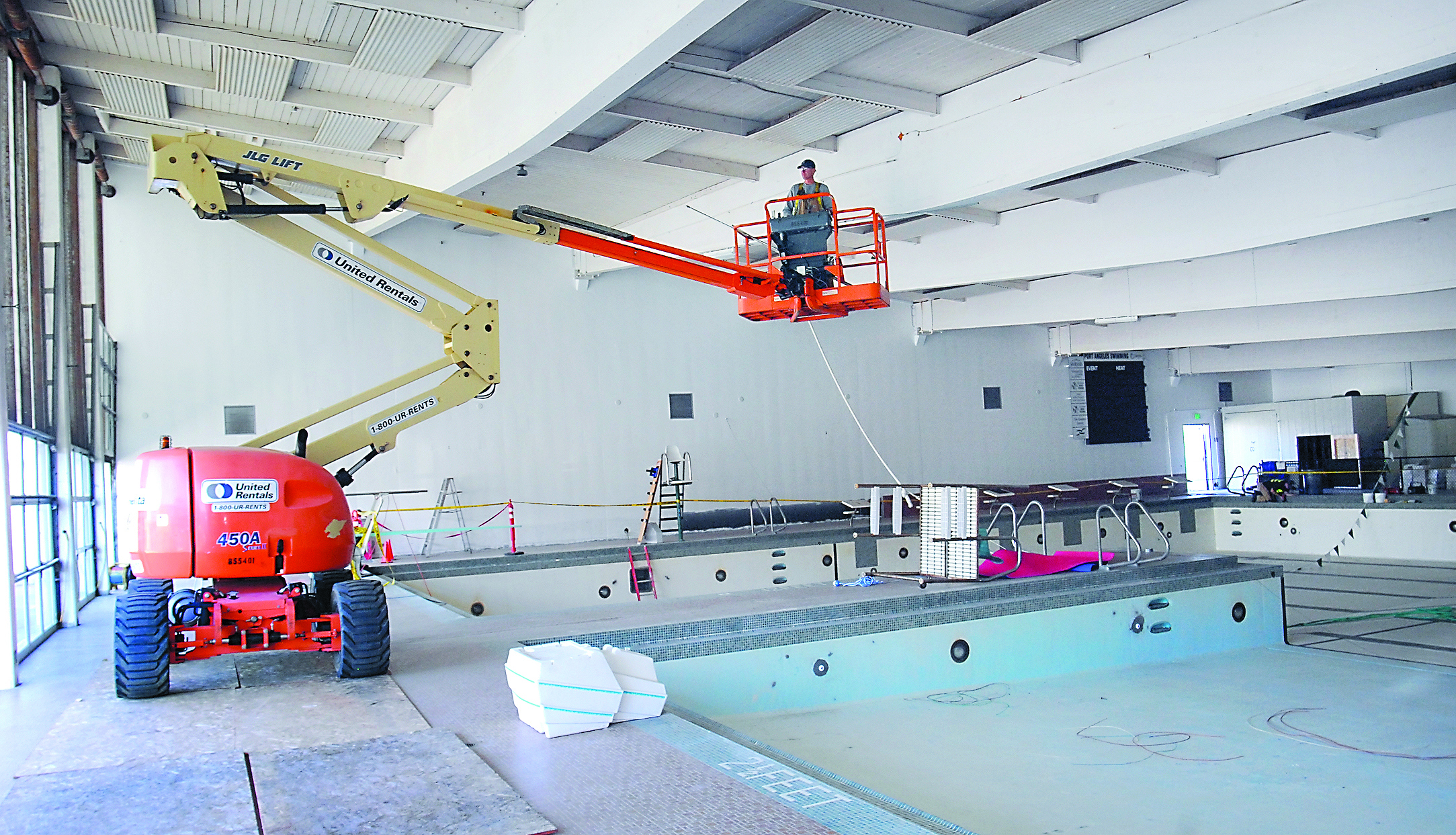 Matthew Downing of North Olympic Electric works on a lift boom Wednesday on a project to replace lighting at William Shore Memorial Pool in Port Angeles. Keith Thorpe/Peninsula Daily News