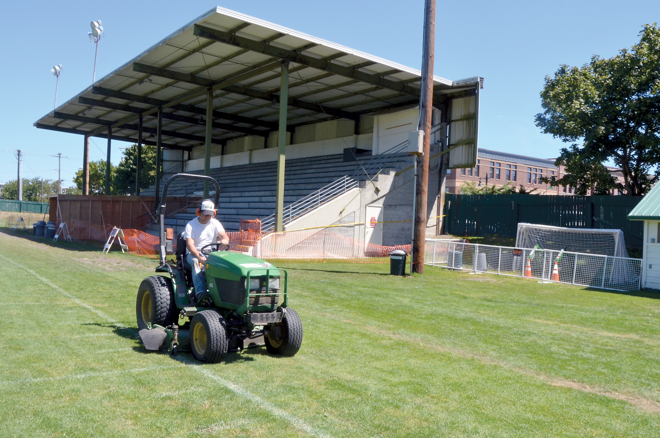 Jefferson County employee Glenn Britlaw mows the area in front of the Memorial Field grandstand in Port Townsend on Thursday. Two initial bids for roof replacement were rejected