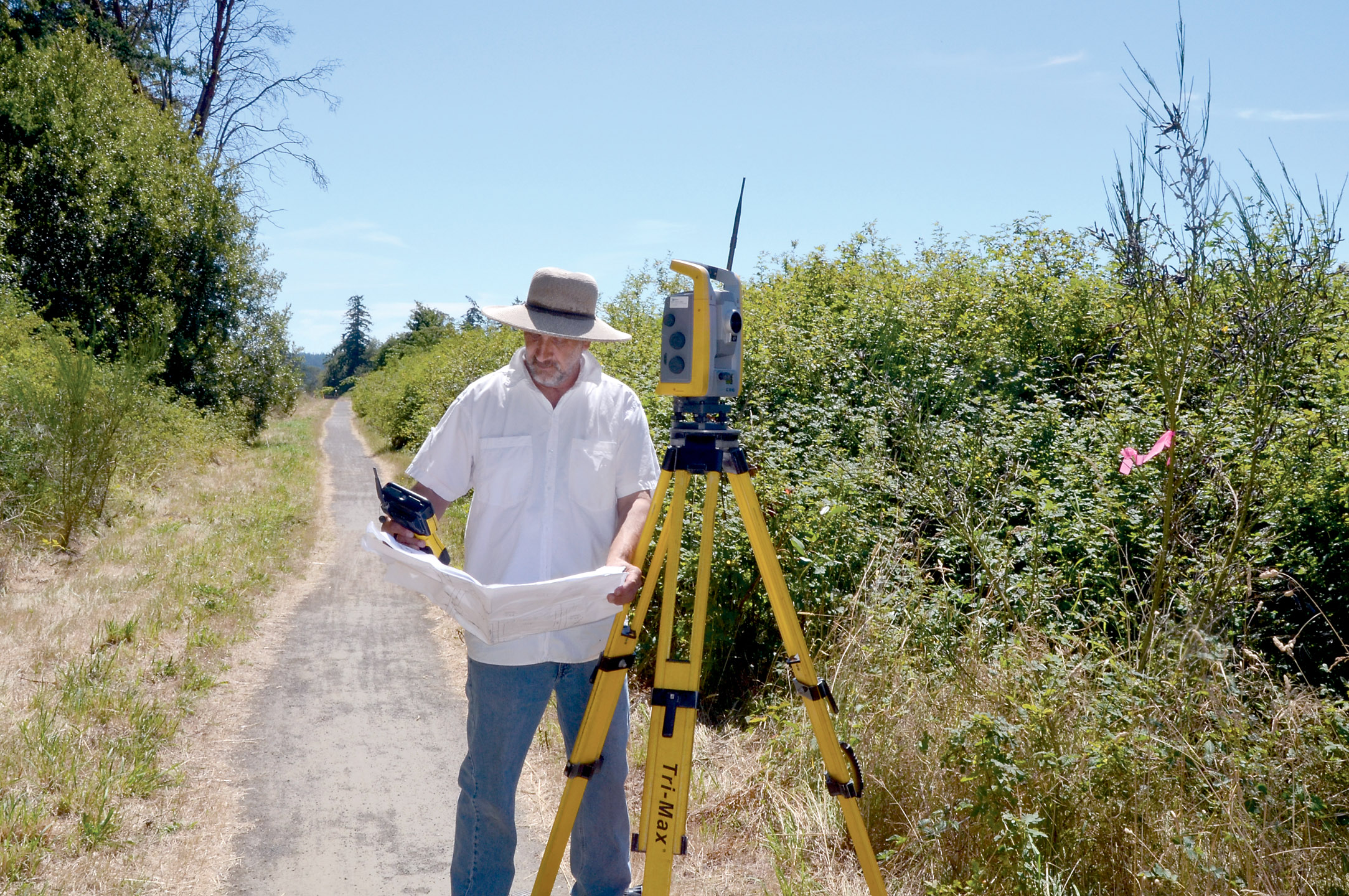 Surveyor Brian Van Aller takes measure of the area that will be used as a right of way connecting Howard Street and Discovery Road. — Charlie Bermant/Peninsula Daily News