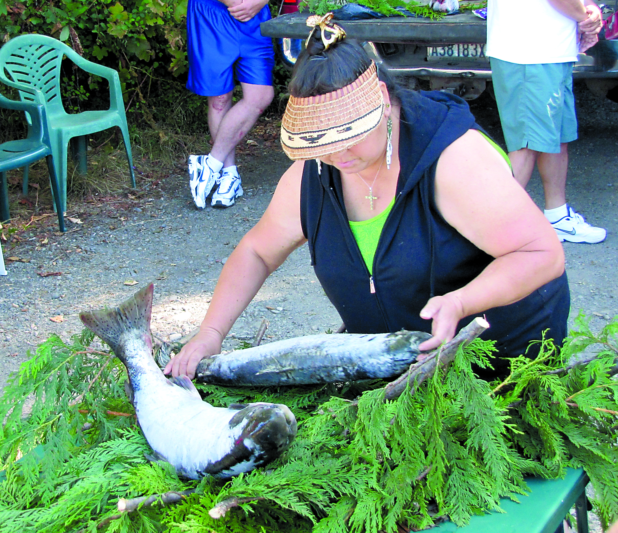 Rachel Hagaman of the Lower Elwha Klallam tribe places two king salmon on a bed of cedar boughs during a traditional ceremony to welcome the salmon back to the Elwha River.  -- Photo by Arwyn Rice/Peninsula Daily News
