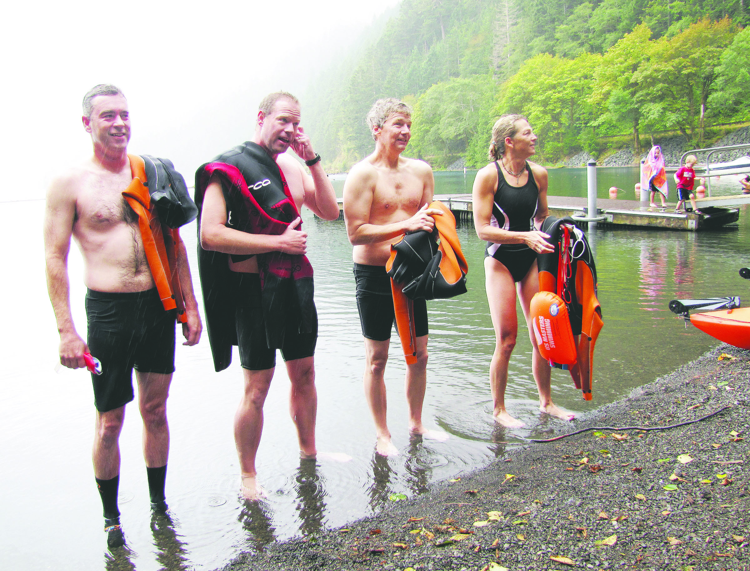 The four swimmers step out of the water after completing their swim along the length of Lake Crescent. From left are Shawn Delplain