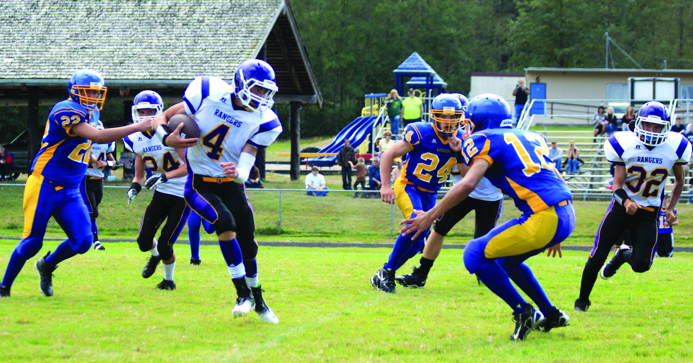 Quilcene quarterback Jacob Pleines (4) looks for an opening upfield against Crescent defenders Wyatt McNeese (22)