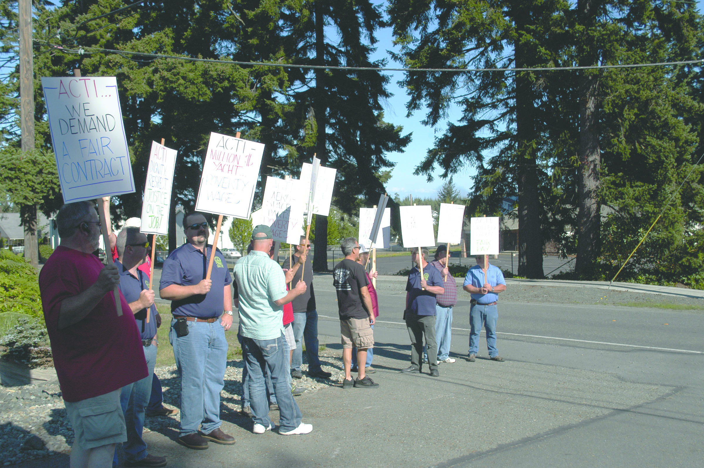 Pickets hold signs outside the Angeles Composite Technologies Inc. plant in west Port Angeles on Monday. -- Photo by Rob Ollikainen/Peninsula Daily News