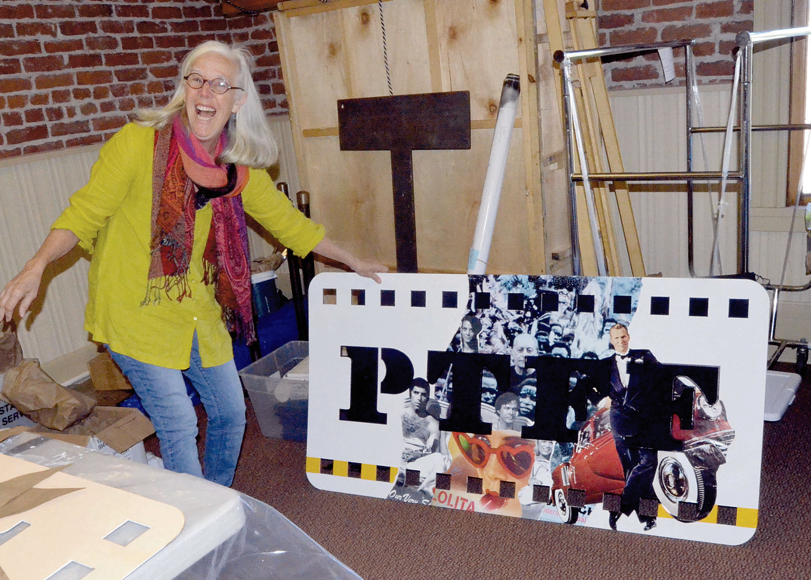 Port Townsend Film Festival Executive Director Janette Force shows off some of the signs that will be used to promote the festival that begins Friday. Charlie Bermant/Peninsula Daily News