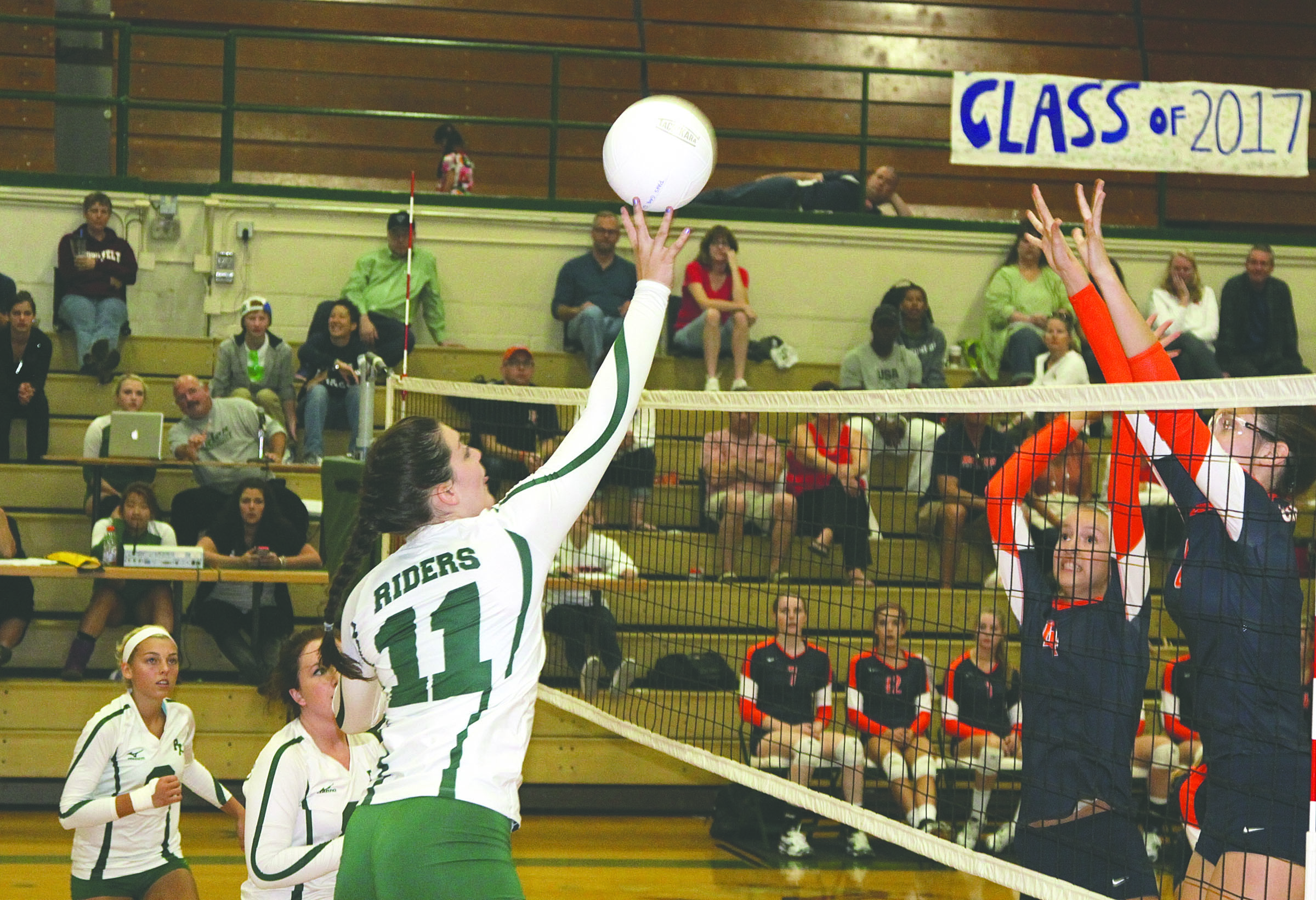 Port Angeles' Bailee Jones tips the ball over the net against Kat Towslee of Eastside Catholic. Dave Logan/for Peninsula Daily News