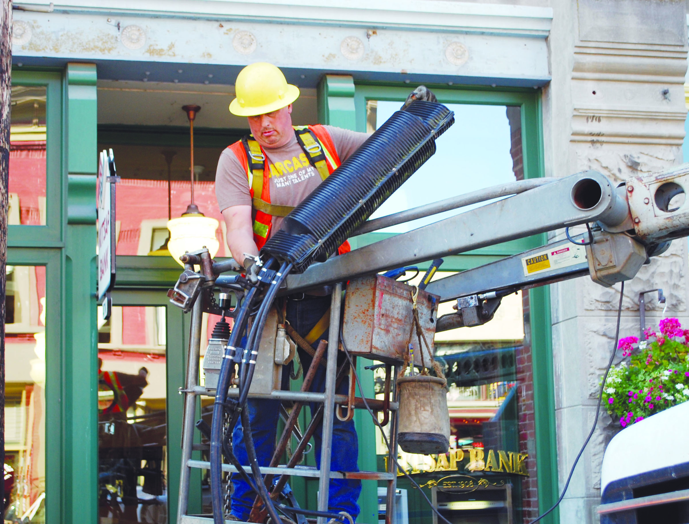 Dave Holman disposes of a splicing box that was on the wires above Taylor Street on Monday. Crews are working to take all the poles in time for the Port Townsend Film Festival
