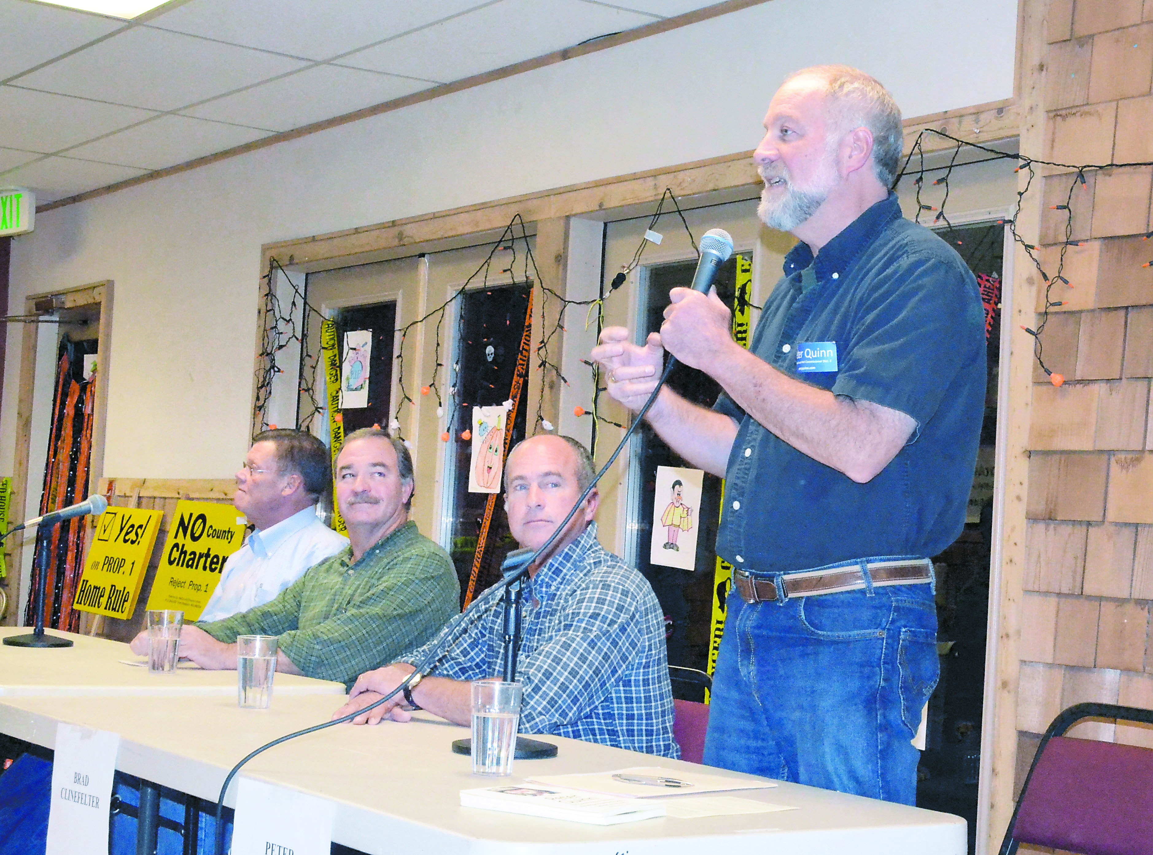Port of Port Townsend commissioner candidate Peter Quinn stands to answer a question at a candidate forum on Tuesday night in Quilcene. Other ort candidates at the forum are (from left) Leif Erickson