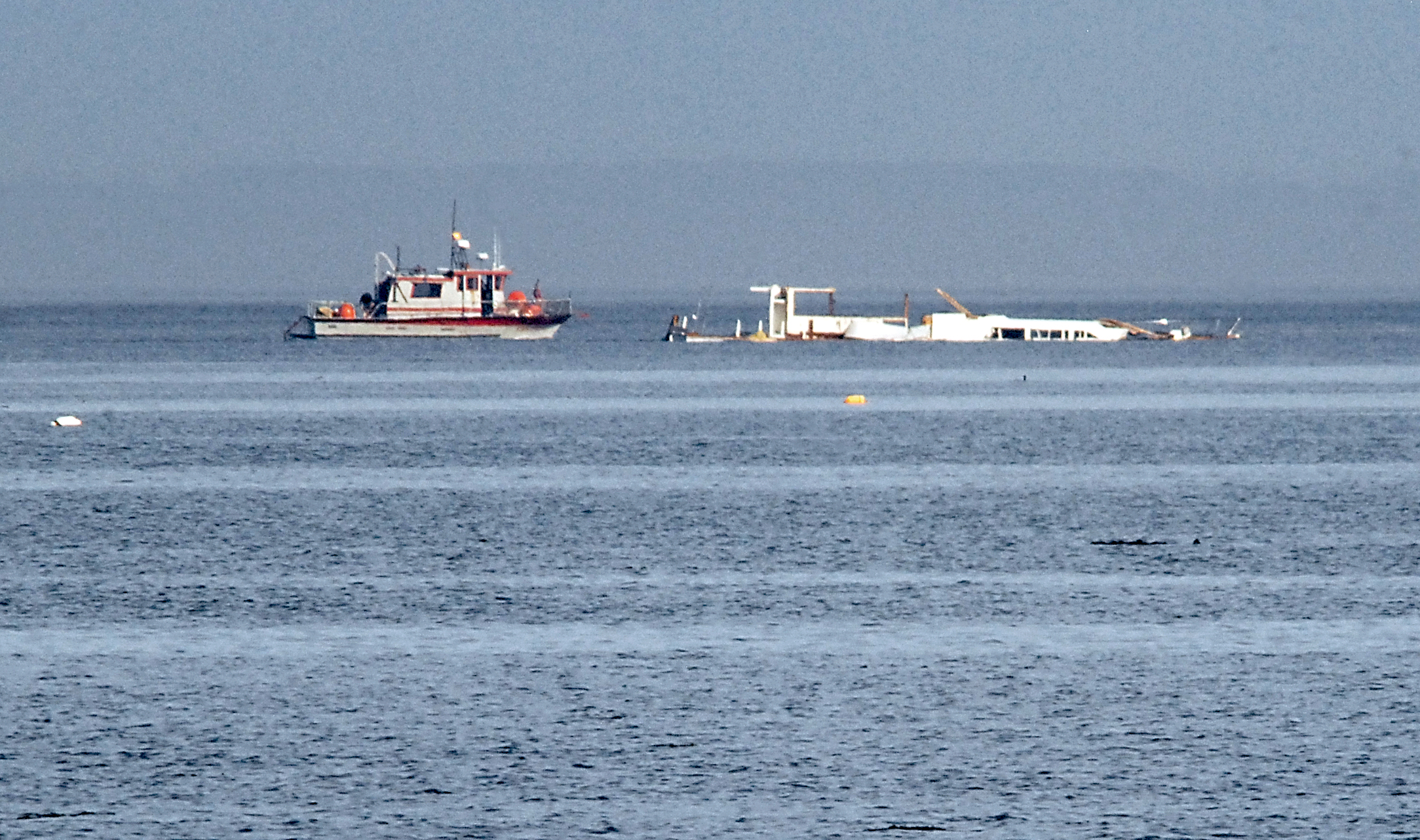 A support boat keeps station with the partially refloated Lady A on Saturday northwest of Three Crabs Road near Dungeness. —Photo by Keith Thorpe/Peninsula Daily News