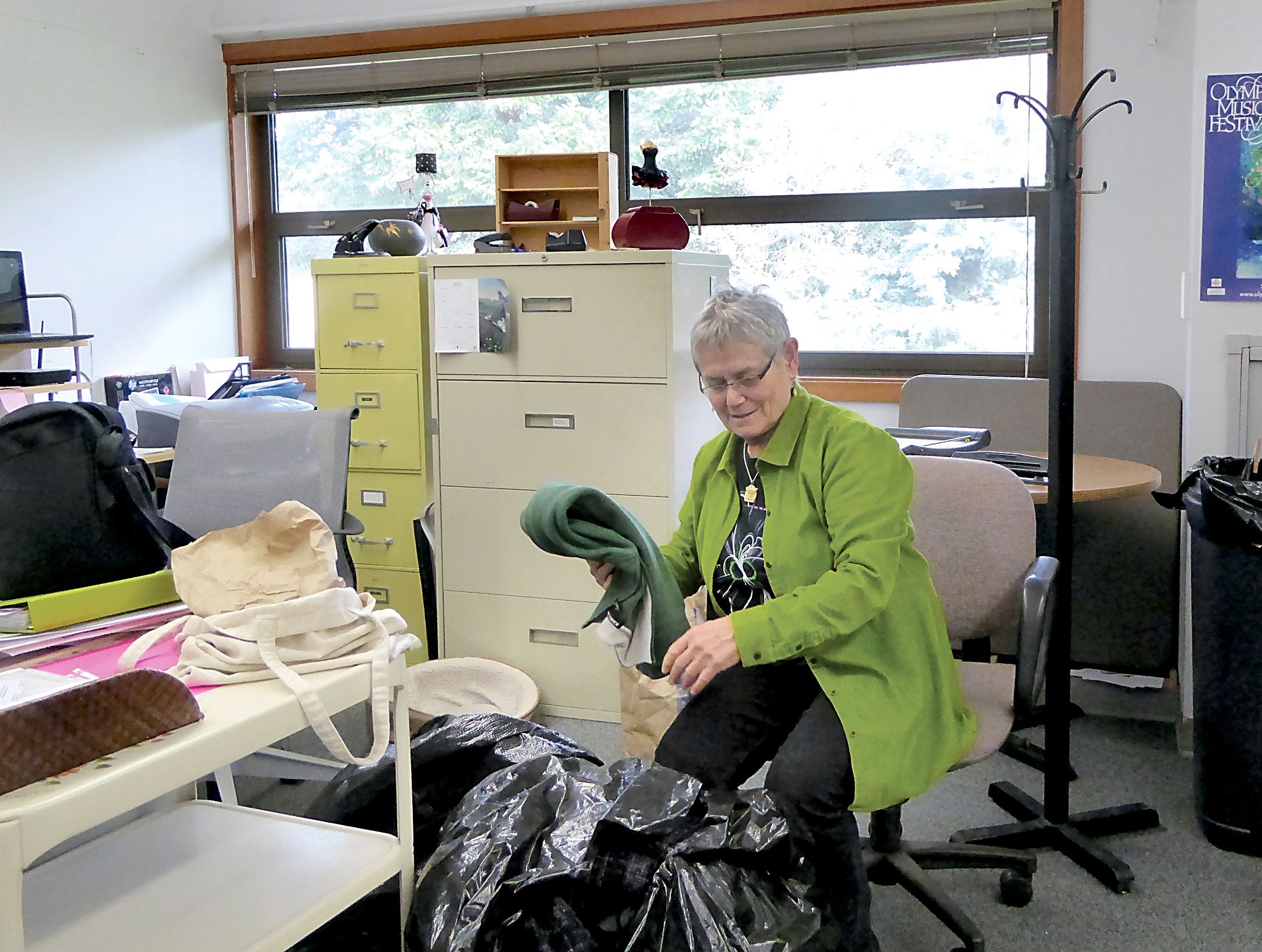 Working Image office manager Liz Berman sorts through some of the donations collected for use by low income women seeking to enter the workforce. — Charlie Bermant/Peninsula Daily News