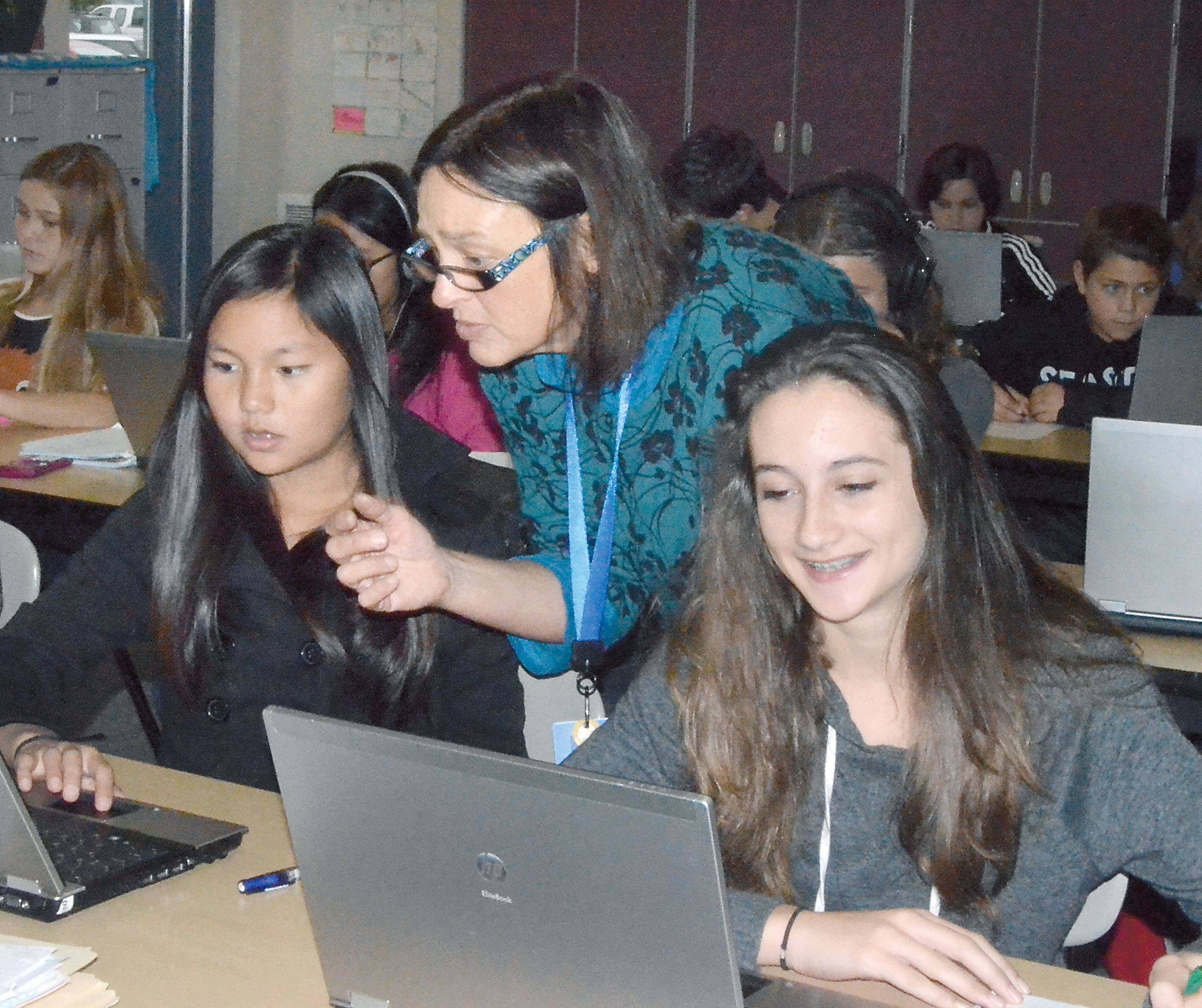 Blue Heron Middle School math teacher Melinda Pongrey helps eighth-graders Leianna Kunzand