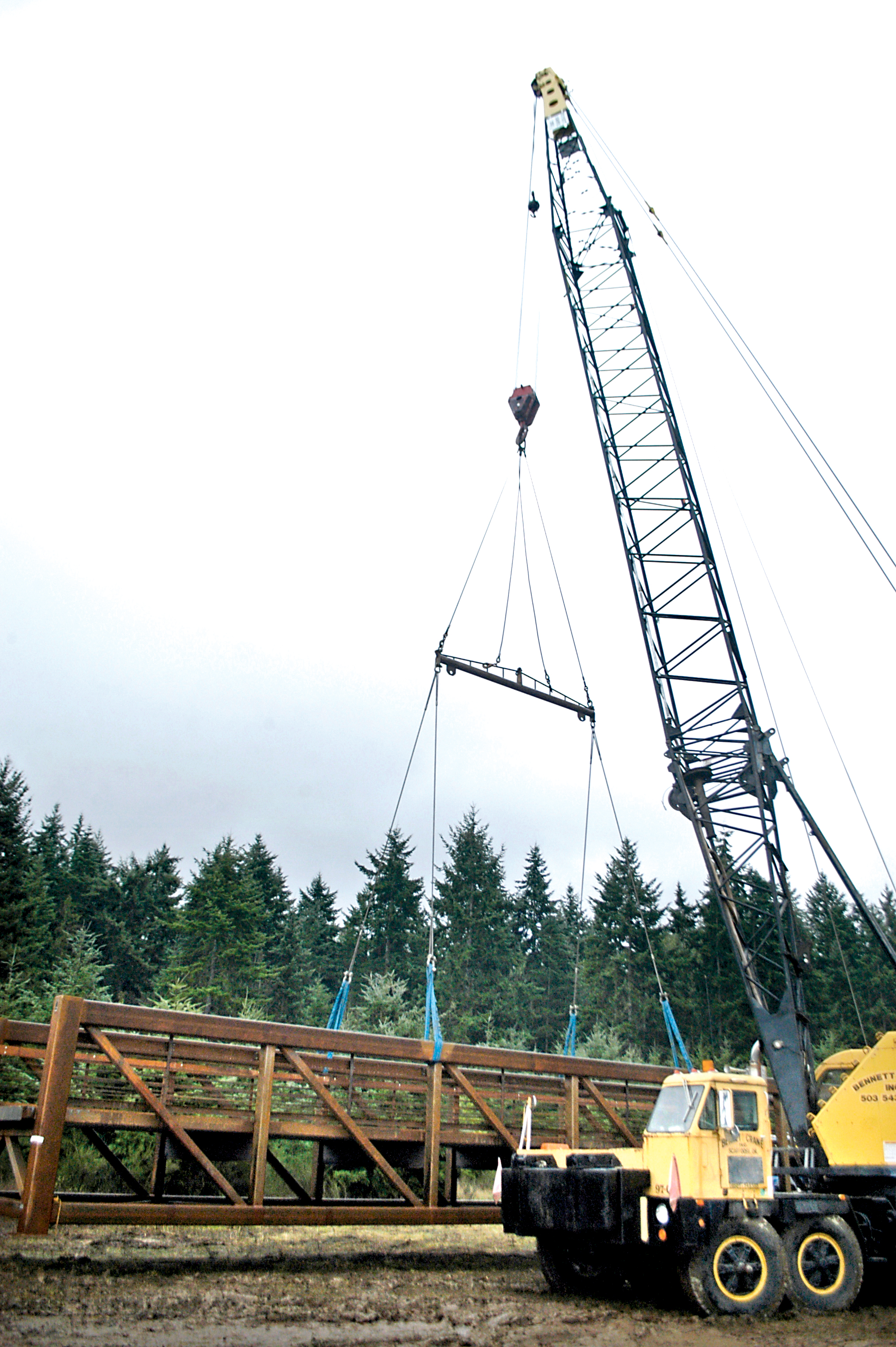 Construction crews are busy Thursday morning preparing this 182-foot-long steel truss span section for installation on the western trestle of the Dungeness River Bridge. Chris McDaniel/Peninsula Daily News