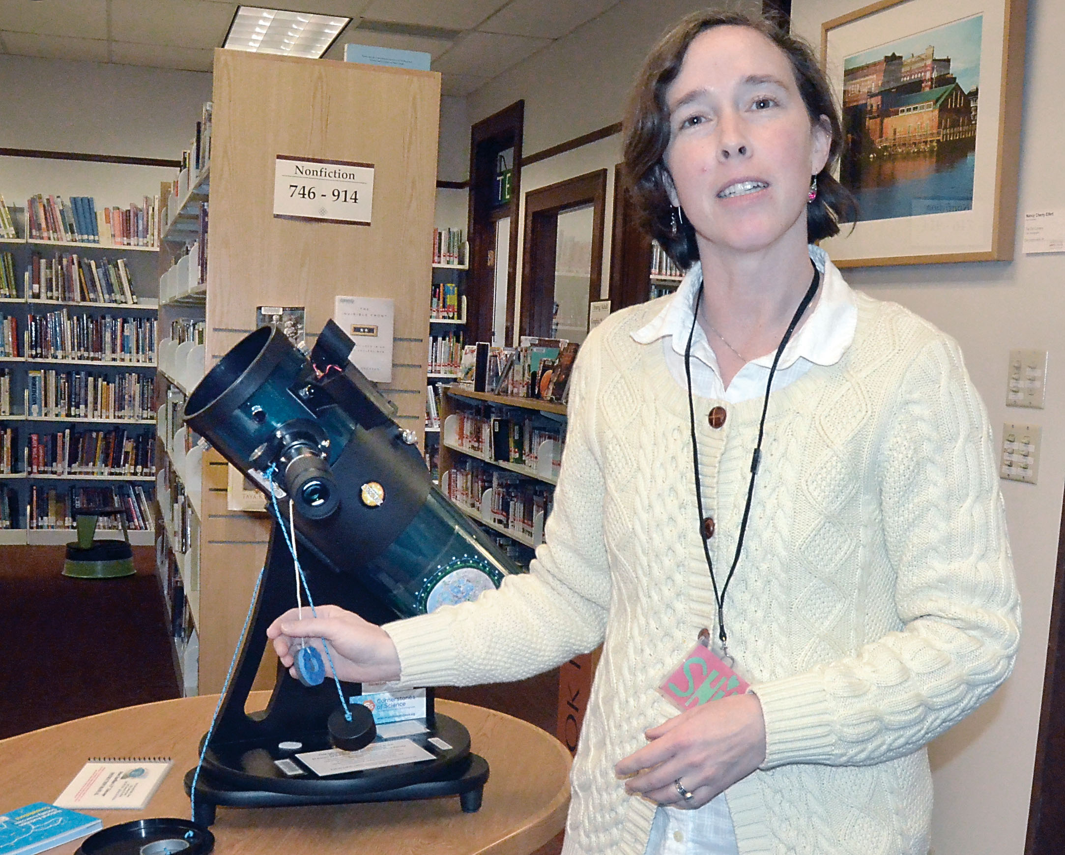 Port Townsend Library assistant Shilah Gould is shown with the telescope that is available for loan. — Charlie Bermant/Peninsula Daily News