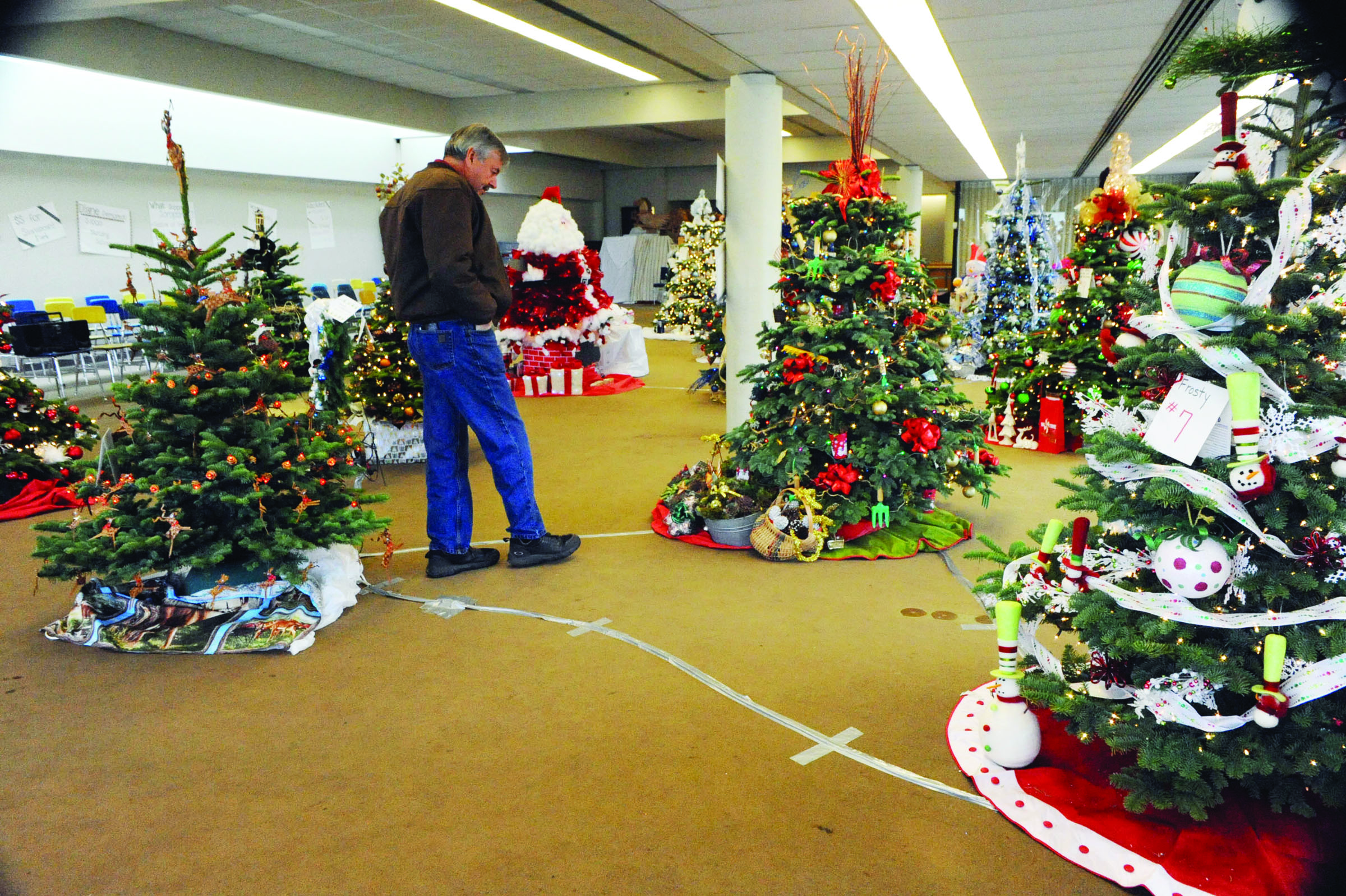Don Grafstrom of Forks looks over the Christmas trees on display during the 2011 Festival of Trees in Forks. Lonnie Archibald/for Peninsula Daily News