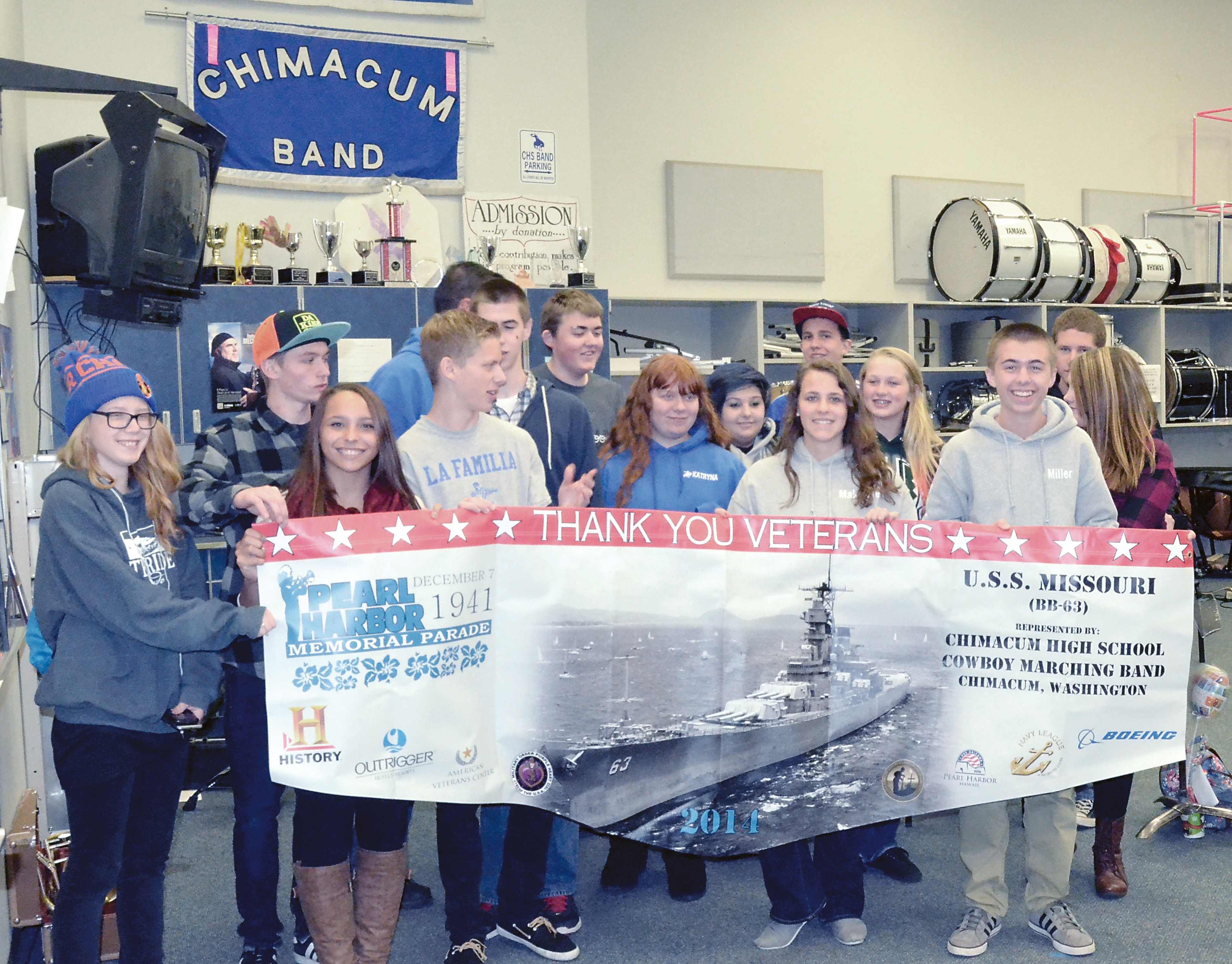 Members of the Chimacum High School Marching Band who made it to class Tuesday morning display the banner they used in Sunday's Pearl Harbor Memorial Parade. The banner will be displayed during its parade appearances next year. Charlie Bermant/Peninsula Daily News