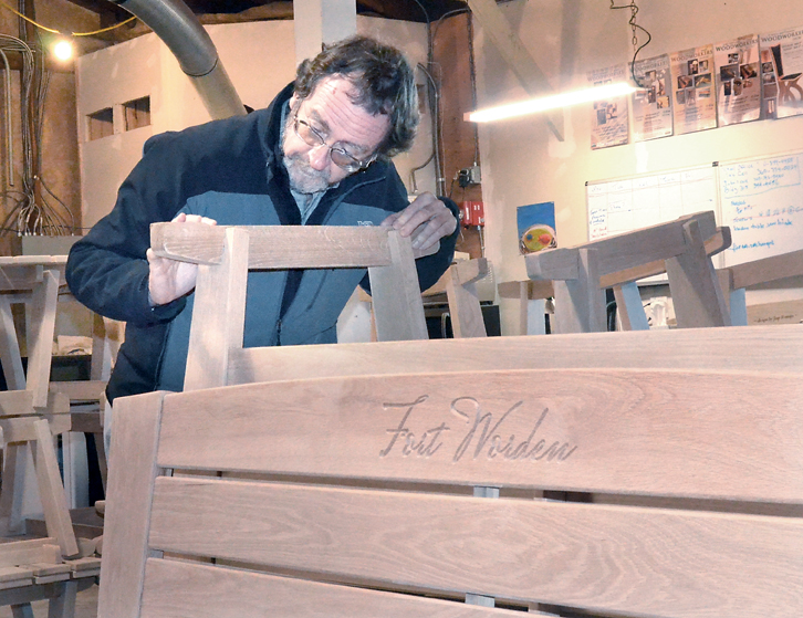 Port Townsend School of Woodworking Executive Director Tim Lawson inspects benches that will be installed on several Fort Worden porches. — Charlie Bermant/Peninsula Daily News