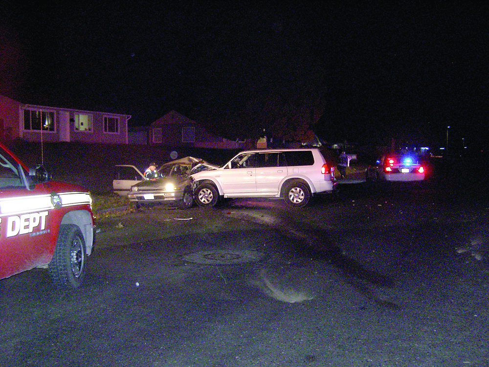 A white 2000 Mitsubishi sport utility vehicle and a tan 1988 Honda Accord sit on the north side of Caroline Street