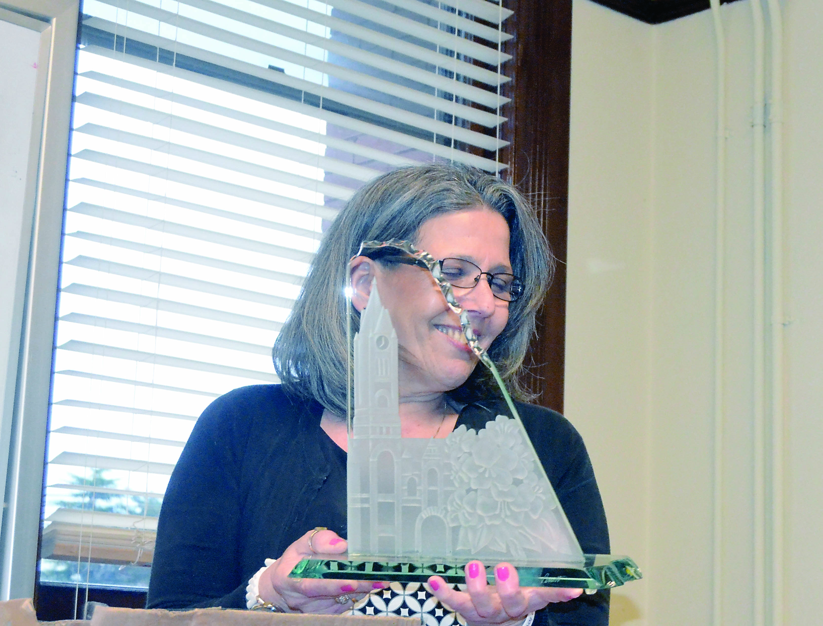 Elections Supervisor Karen Cartmel holds a plaque depicting the Jefferson County Courthouse at her retirement party.  —Photo by Charlie Bermant/Peninsula Daily News