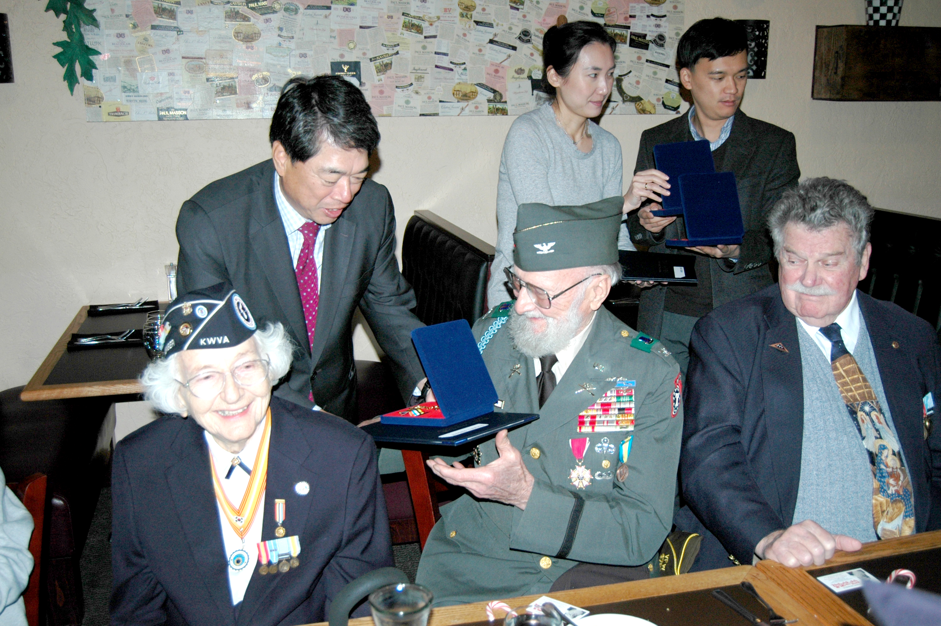 Republic of Korea Consul General Moon Duk-ho presents his country’s Ambassador for Peace medal to Korean War veteran Don Roberts at a luncheon Monday. At left is former Army nurse Mary Reid