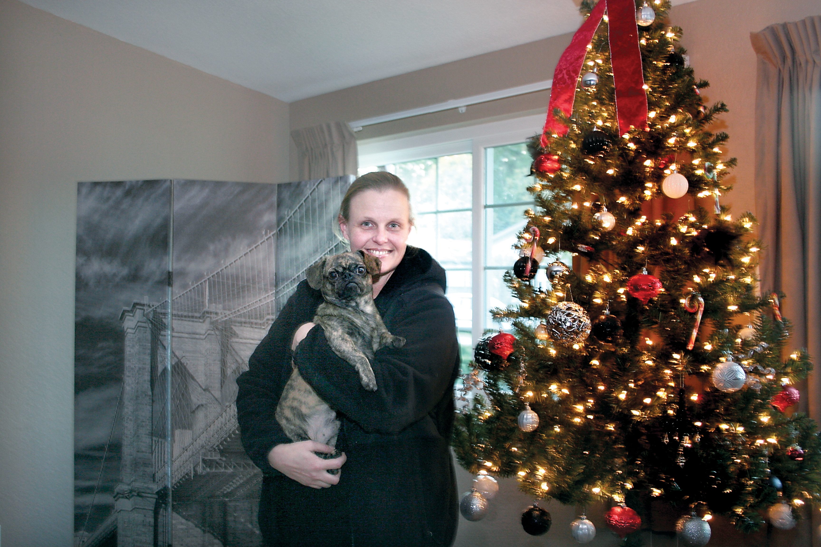 Dawn Madary holds her dog Rover in a home she was able to rent in time for the holidays with help from the Peninsula Daily News' Home Fund. — Karen Griffiths/for Peninsula Daily News