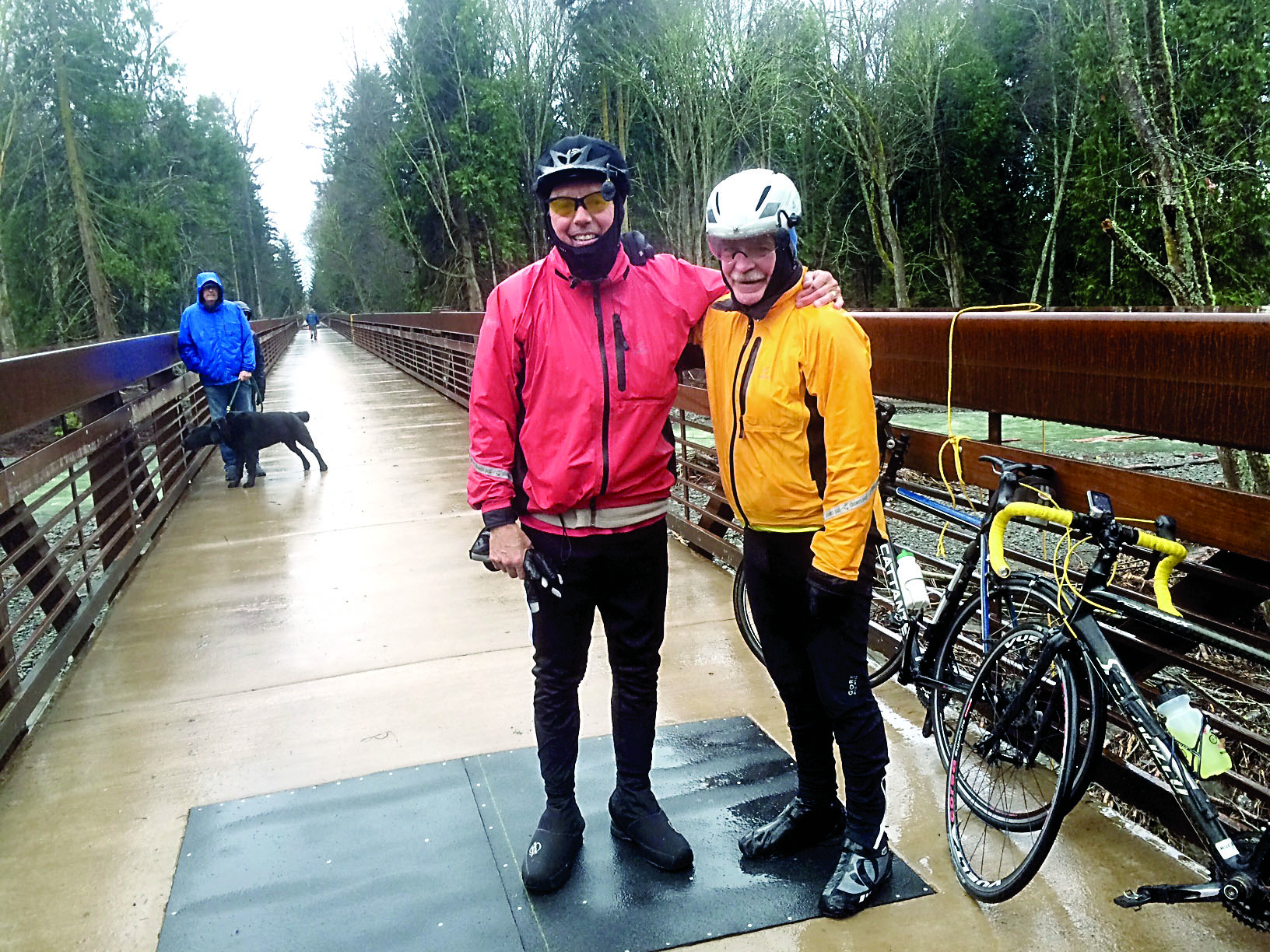 Garland Frankfurth and Bob Anundson were among the first bicyclists to cross the newly opened trestle Thursday. A bystander helped the two remove a fallen tree from the pathway. — Cheryl Garland