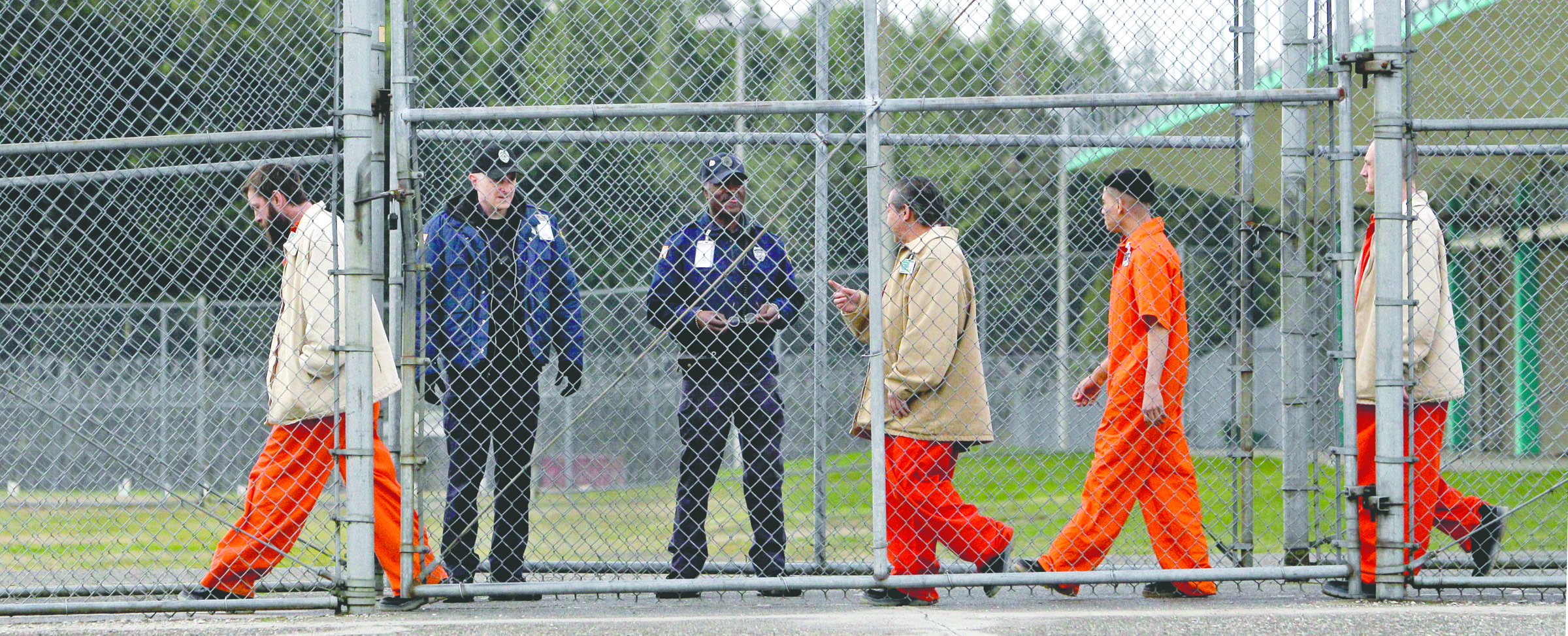 Inmates walk past correctional officers at the Washington Corrections Center in Shelton in February 2011. The Associated Press