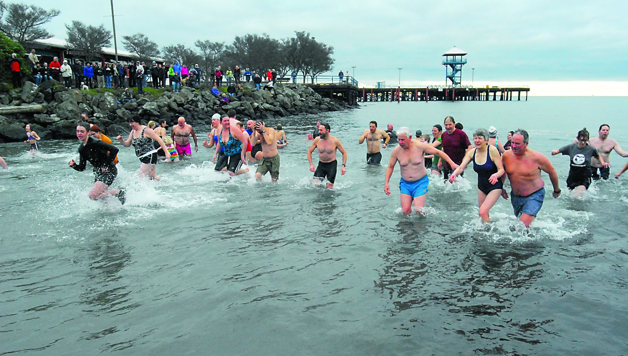 Polar bear dippers rush back out of the chilly waters of Port Angeles Harbor during the 2013 New Year's Day plunge at Hollywood Beach. — Keith Thorpe/Peninsula Daily News