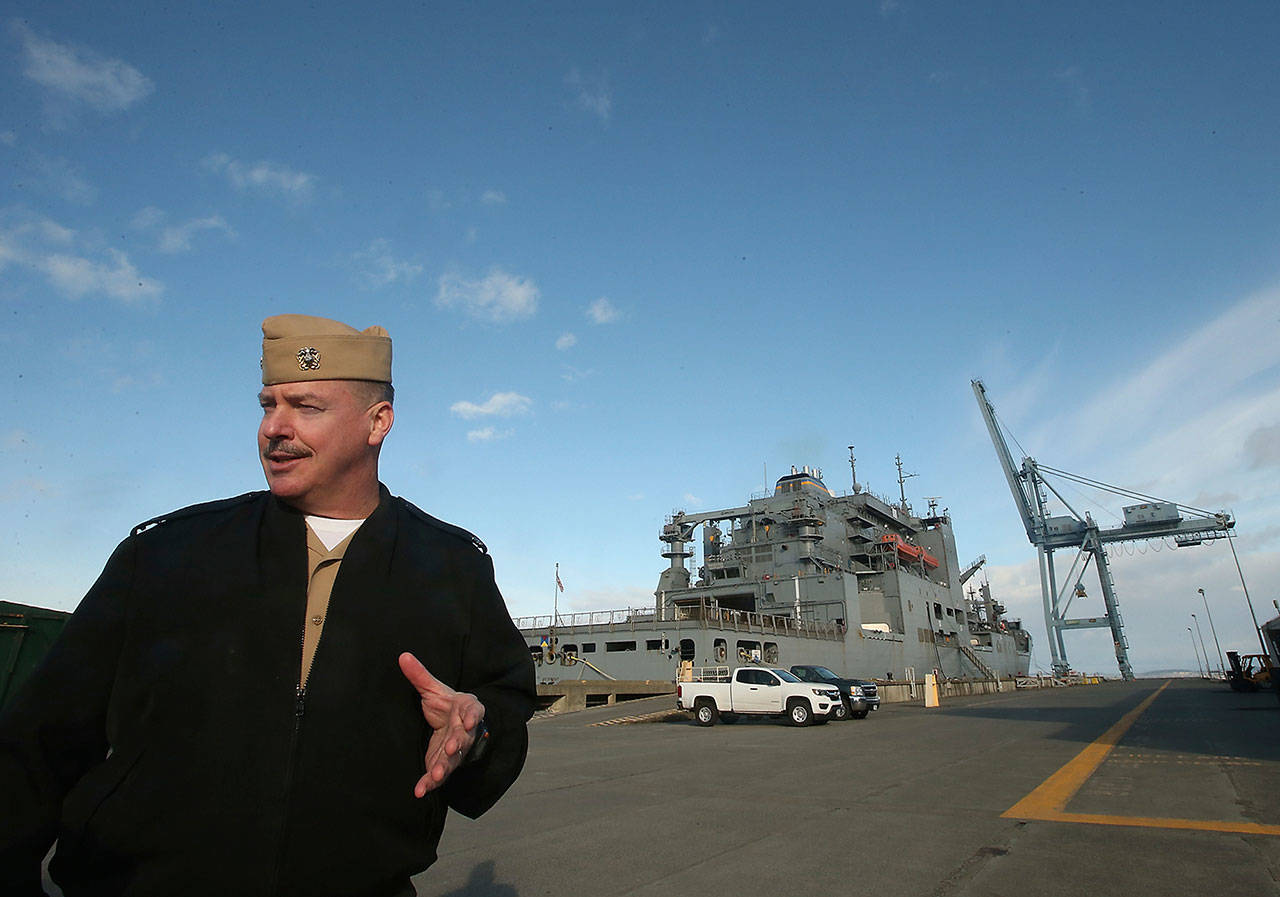 Naval Magazine Indian Island’s Cmdr. Rocky Pulley talks about the process of loading and unloading ships, like the USNS Cesar Chavez behind him, at the pier on Nov. 17. Naval Magazine Indian Island serves as the last stop for many ships, where they load up on “fuel, food and munitions” before heading out to the open ocean, Pulley said. (Meegan M. Reid/Kitsap Sun via AP)