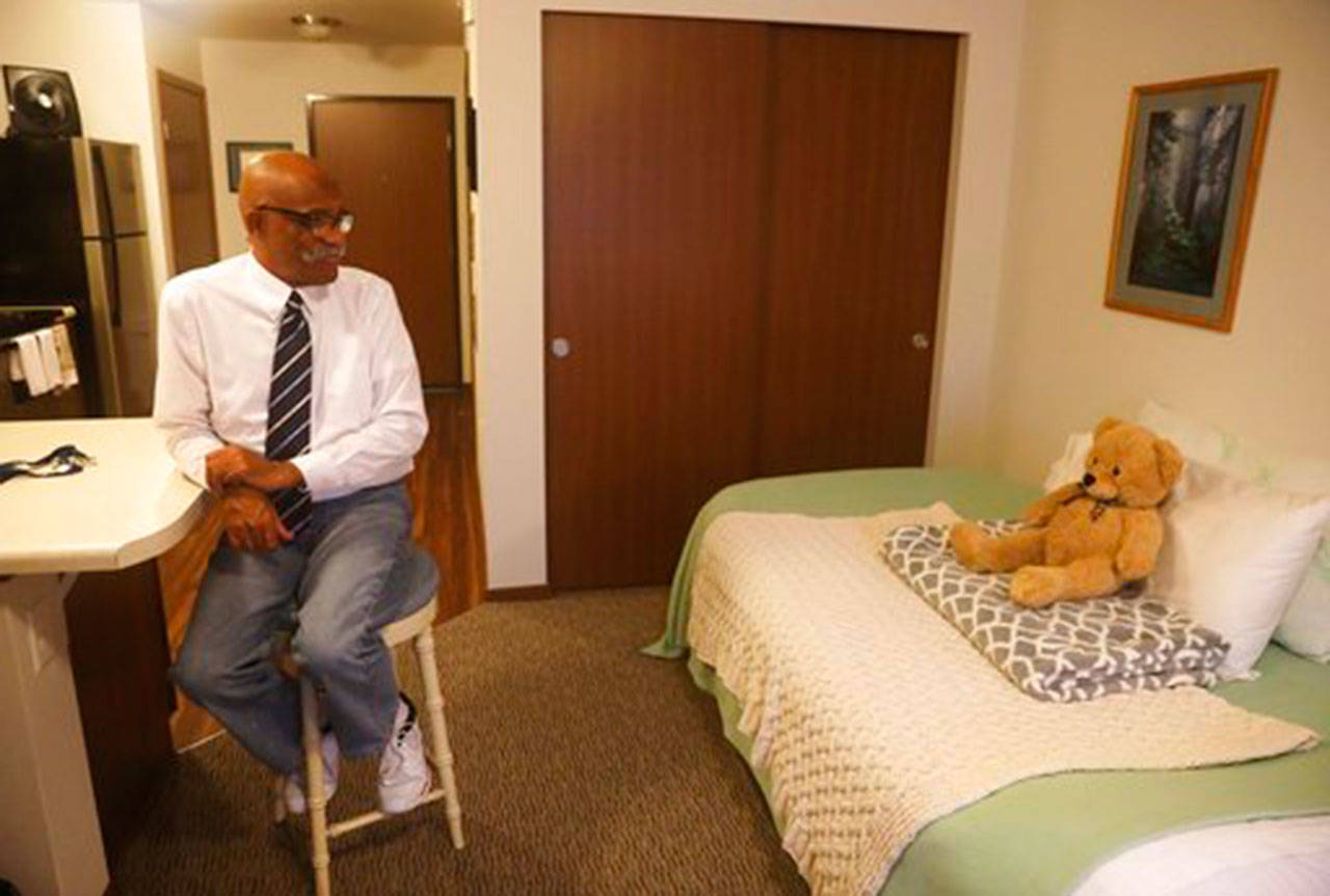 Jack Coleman sits in his apartment in SeaTac on Nov. 21, where he keeps a Teddy bear named Boo-Boo. (Ken Lambert/The Seattle Times via AP)