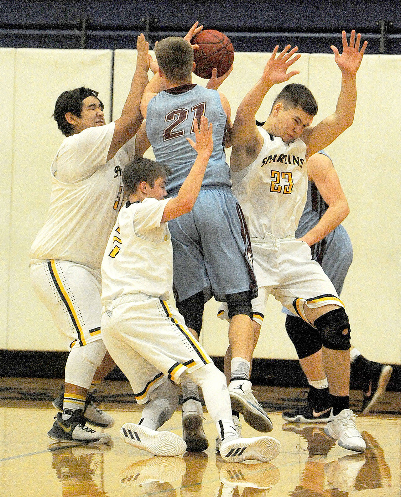 From left, Forks players Iziah Morton, Joseph Reaume and Braton Armas (23) defend against Stevenson’s Isaac Hoidal on Saturday afternoon in Forks. The Spartans defeated Stevenson 73-50. (Lonnie Archibald/for Peninsula Daily News)