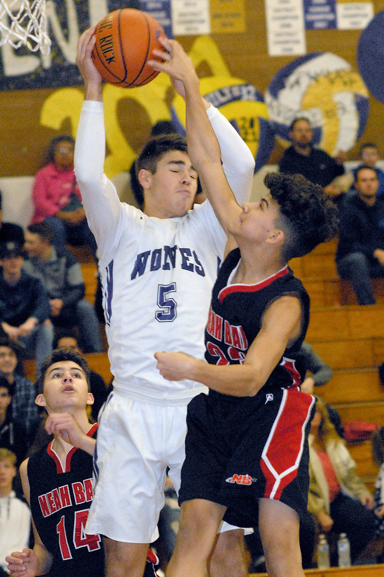 Keith Thorpe/Peninsula Daily News                                Sequim’s Payton Glasser, center, pulls down a rebound between Neah Bay’s Jay Brunk, left, and Jaxson Halttunen in the first quarter Tuesday in Sequim.