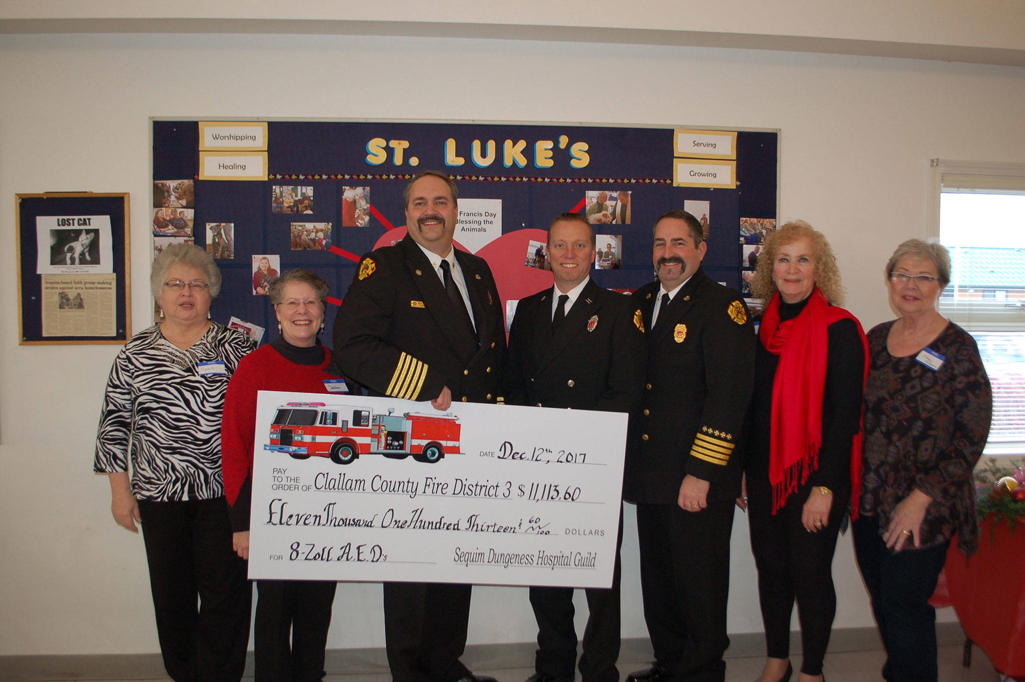 The Sequim-Dungeness Hospital Guild donated more than $11,000 to Clallam County Fire District 3 at the guild’s annual appreciation luncheon last Tuesday. Guild members Anna Gregory, left, and Debbie Kahle stand with Fire Chief Ben Andrews, Capt. Derrell Sharp, Assistant Chief Tony Hudson, guild President Jean Janis and Nancy McGovern at St. Luke’s Episcopal Church. (Erin Hawkins/Olympic Peninsula News Group)