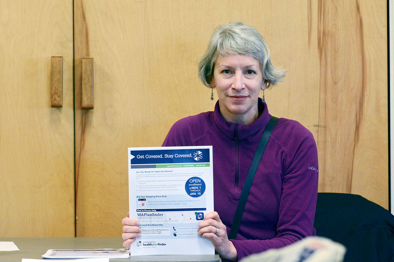 Angela Gyurko sits at St. Paul’s Episcopal Church’s Just Soup, offering information about how to sign up for health insurance Wednesday. (Jesse Major/Peninsula Daily News)