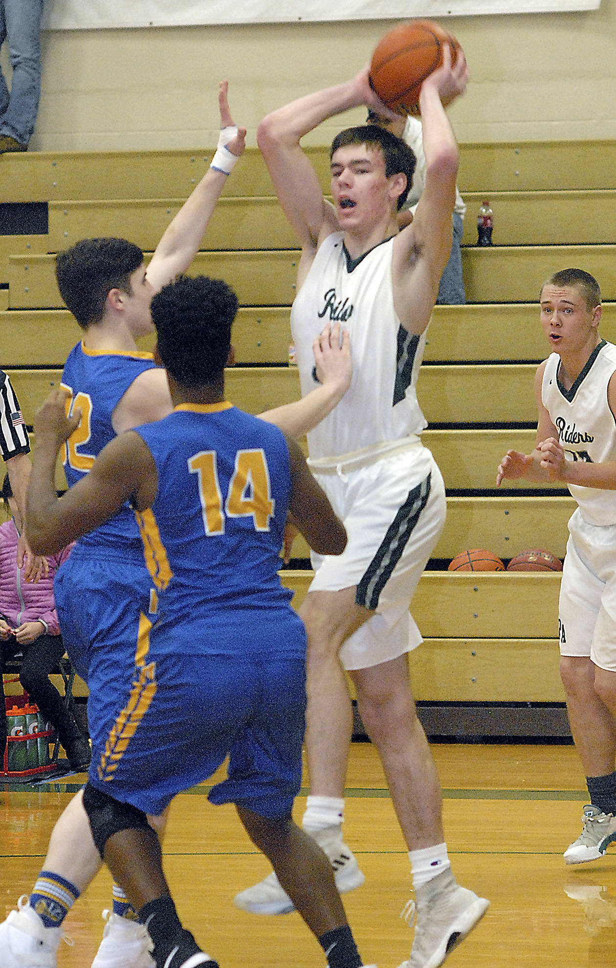 <strong>Keith Thorpe</strong>/Peninsula Daily News Port Angeles’ Liam Clark, top, looks to pass over the heads of Rochester’s Jarrett Smith, left, and Stephen Robinson Friday during the first round of the Port Angeles Holiday Basketball Tournament. Looking on at right is Port Angeles’ Easton Joslin.