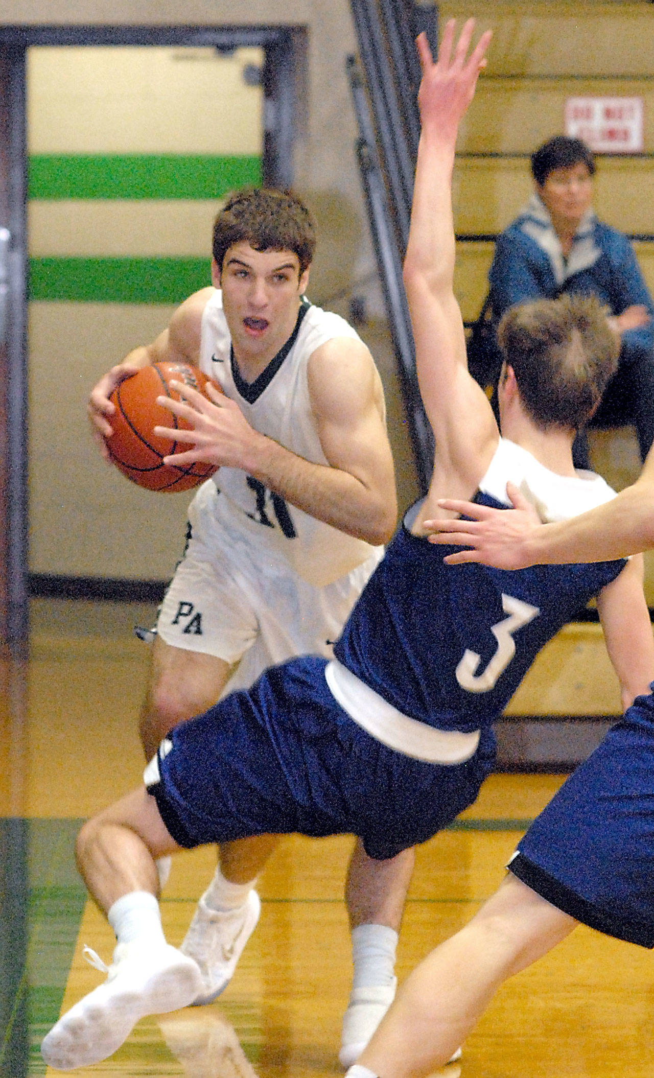 Keith Thorpe/Peninsula Daily News Port Angeles’ Garrett Edwards, left, drives to the lane through Sedro-Woolley’s Cade Isakson during Saturday nigh’s championship round of the Port Angeles Holiday Basketball Tournament.