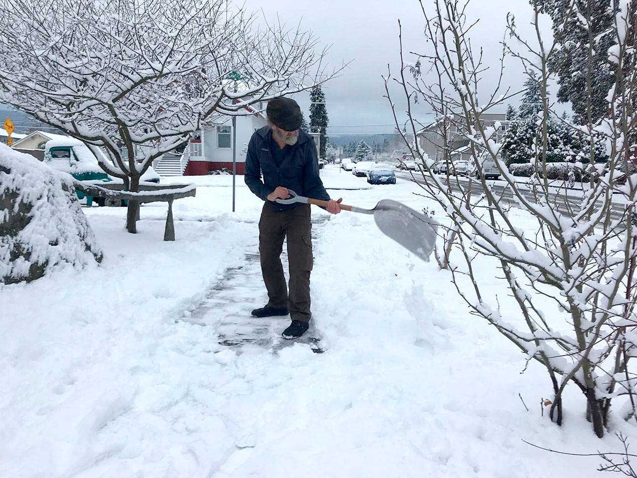 Paul Gottlieb/Peninsula Daily News Greg Shield shoveled snow Christmas morning from the sidewalk in front of his house at Cedar and West Seventh streets in Port Angeles. About 5 inches fell in the neighborhood.
