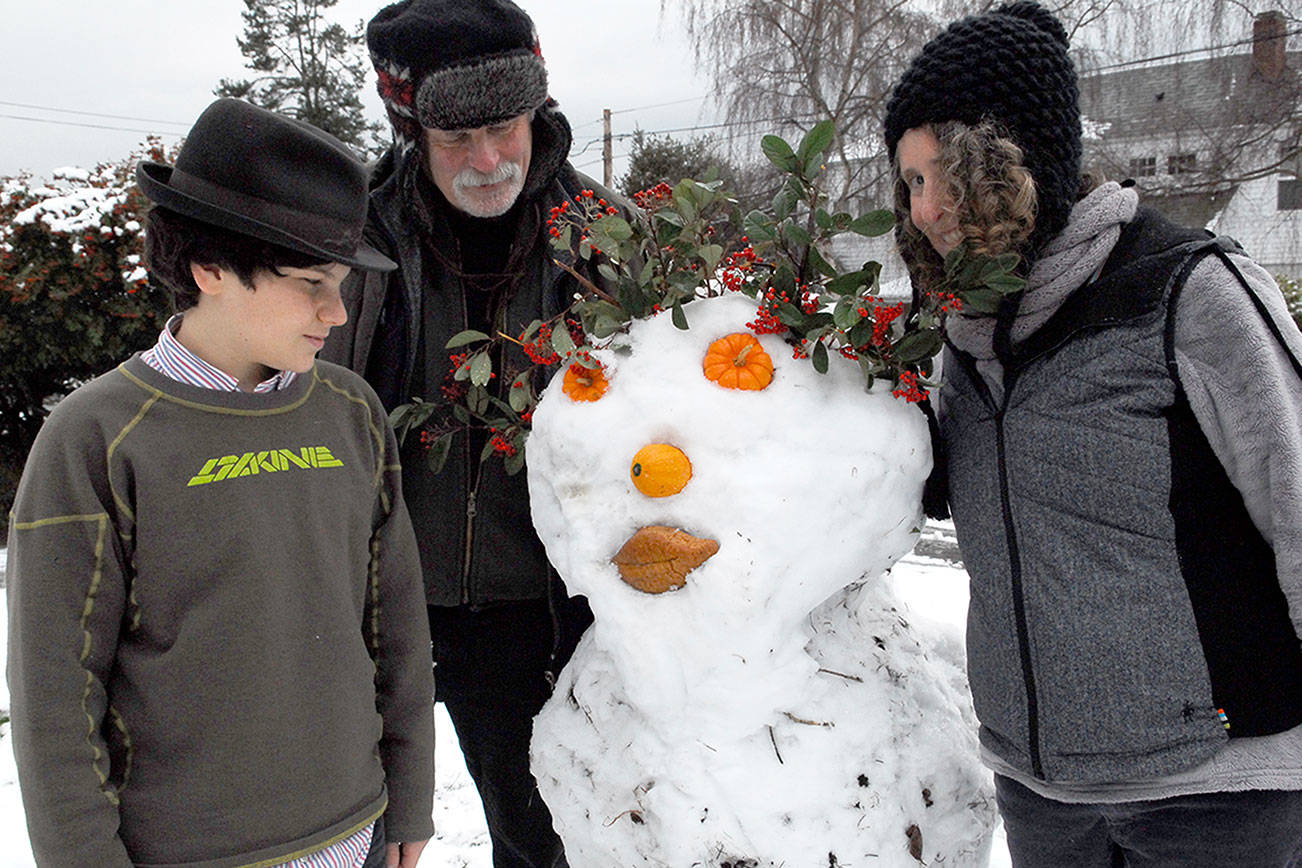 Oscar, Michael and Ruth Levine of Walker Street, Port Townsend, created a snowman for their neighbors as a Christmas surprise.They used volunteer plant material, repurposed Halloween mini-pumpkins, a squash and bread for lips. The project started out as a snowball fight and grew from there. (Jeannie McMacken for Peninsula Daily News).