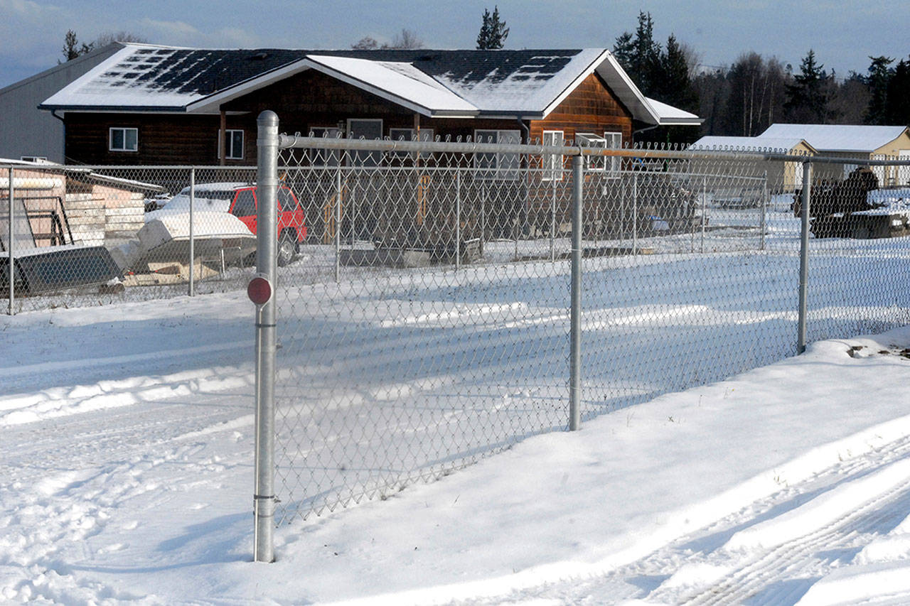 A fence that triggered a property dispute stands along the driveway to a home formerly owned by Barry Swegle, who was convicted of going on rampage with a bulldozer into nearby homes in the Gales Addition east of Port Angeles in May 2013. (Keith Thorpe/Peninsula Daily News)