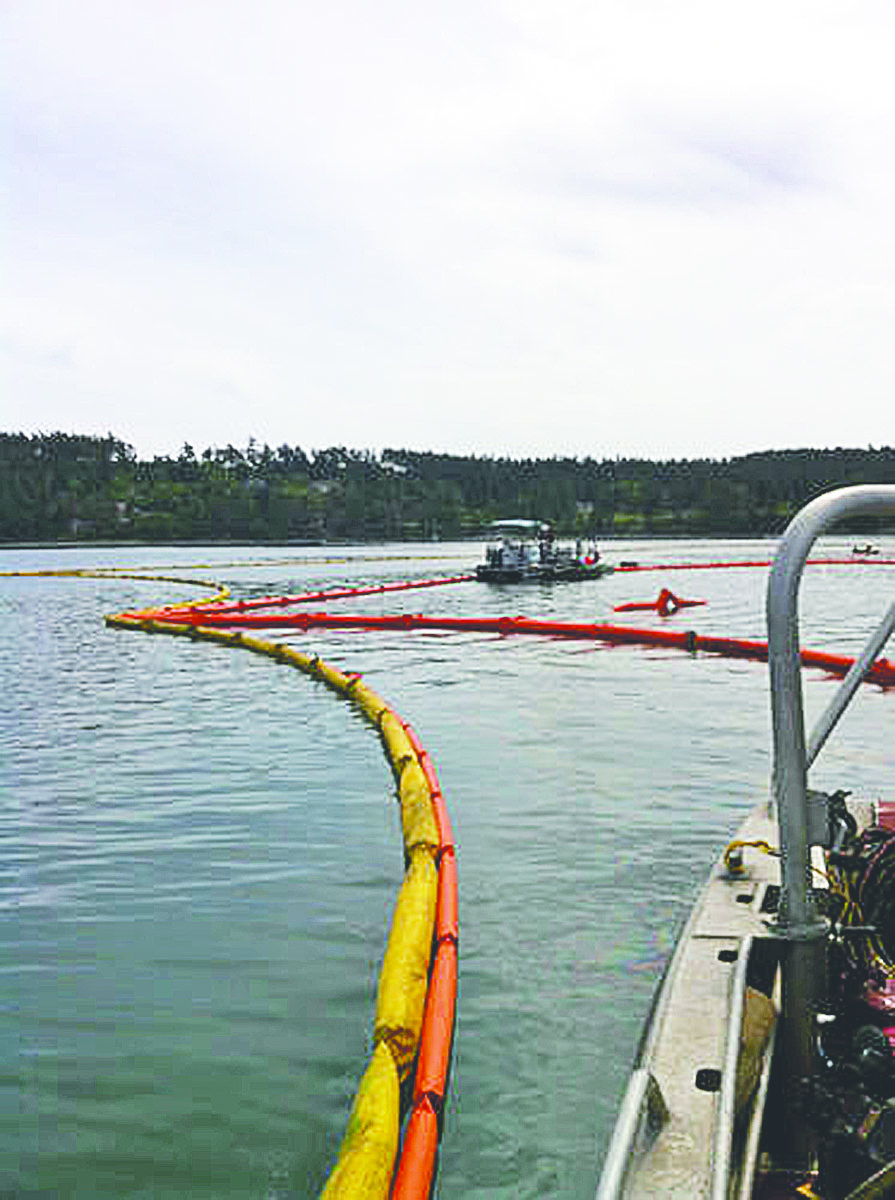 A containment boom is deployed in Penn Cove off Whidbey Island on Tuesday. U.S. Coast Guard
