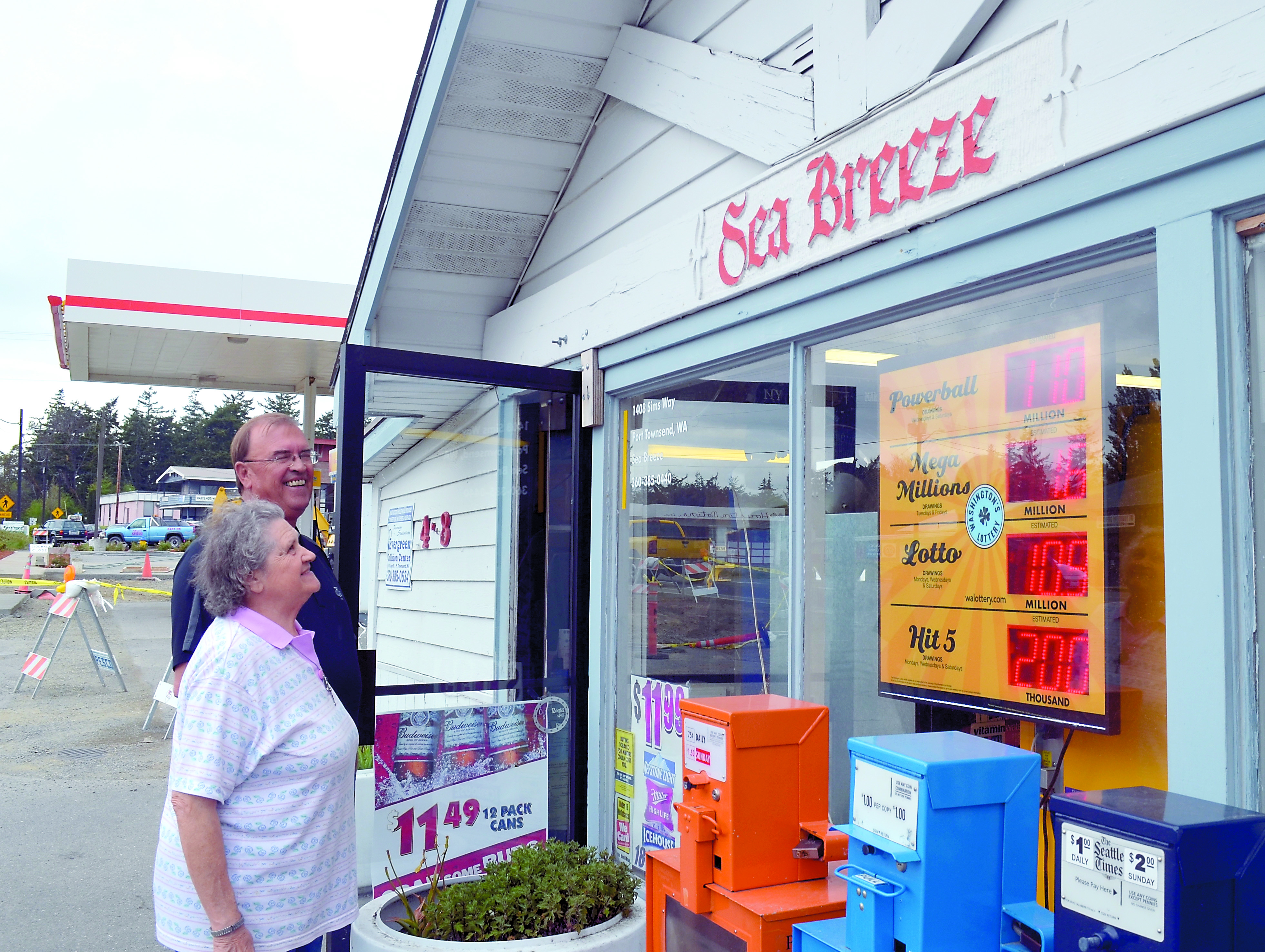 Seabreeze employee Carol Kenyon and contractor Dave Sather inspect the sign at the Sea Breeze. which will be moved to a place of prominence in the store's new location. Charlie Bermant/Peninsula Daily News