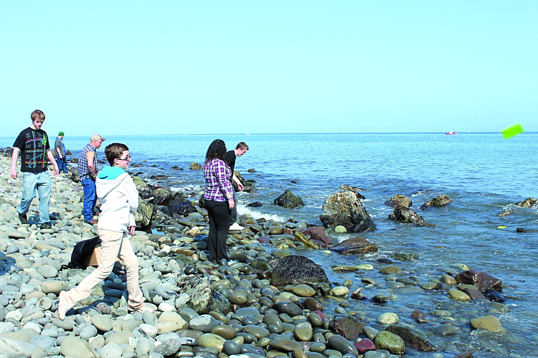 Lincoln High School student Jennah Matheny flings a drift card on May 17 from Ediz Hook. Port Angeles School District