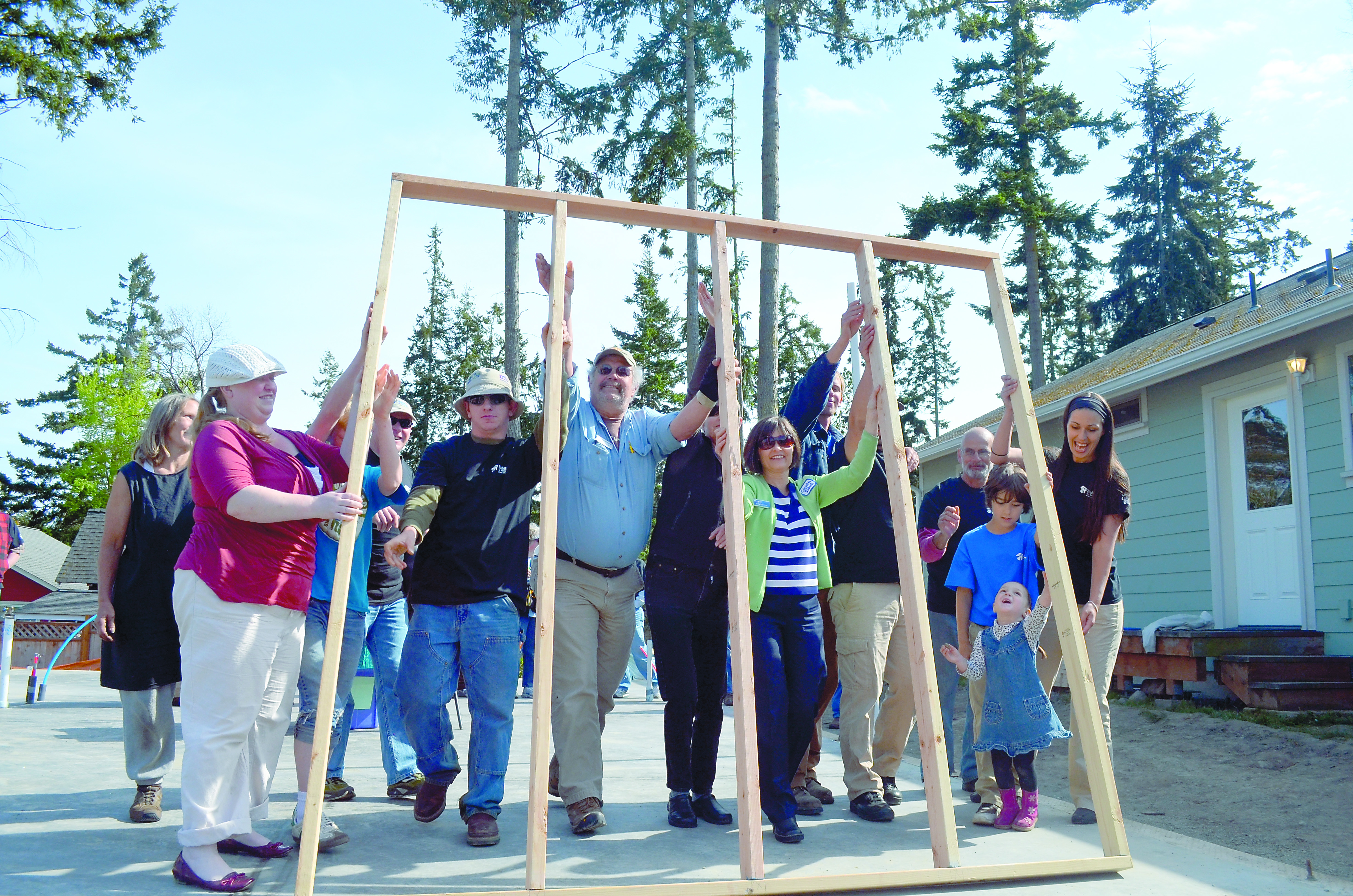 Attendees at a Habitat for Humanity event Tuesday lift a ceremonial wall. Charlie Bermant/Peninsula Daily News
