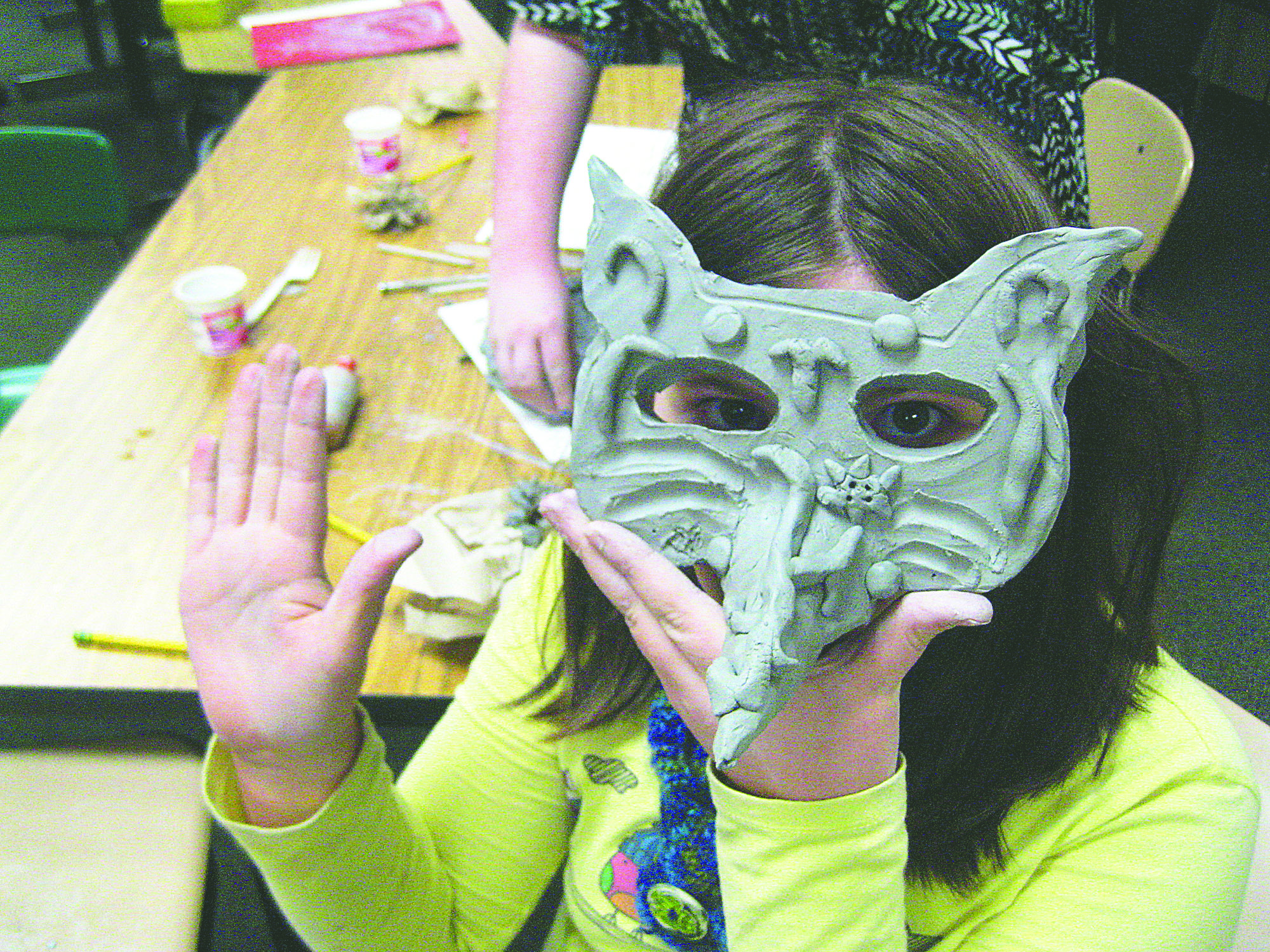Hamilton Elementary School sixth-grader Raine Westfall shows off a mask she created with help from artist and teacher Dani LaBlond. Mask-making and other art activities are open to the public this evening during an art fair hosted by the Port Angeles school.