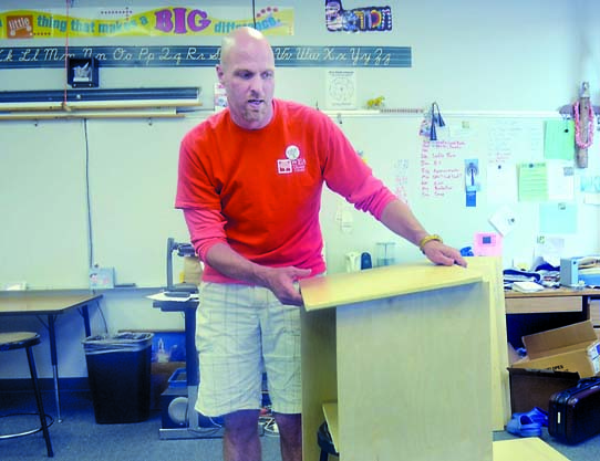 Mitch Brennan shows how he will construct the podiums for his Chimacum Elementary School classroom. Charlie Bermant/Peninsula Daily News
