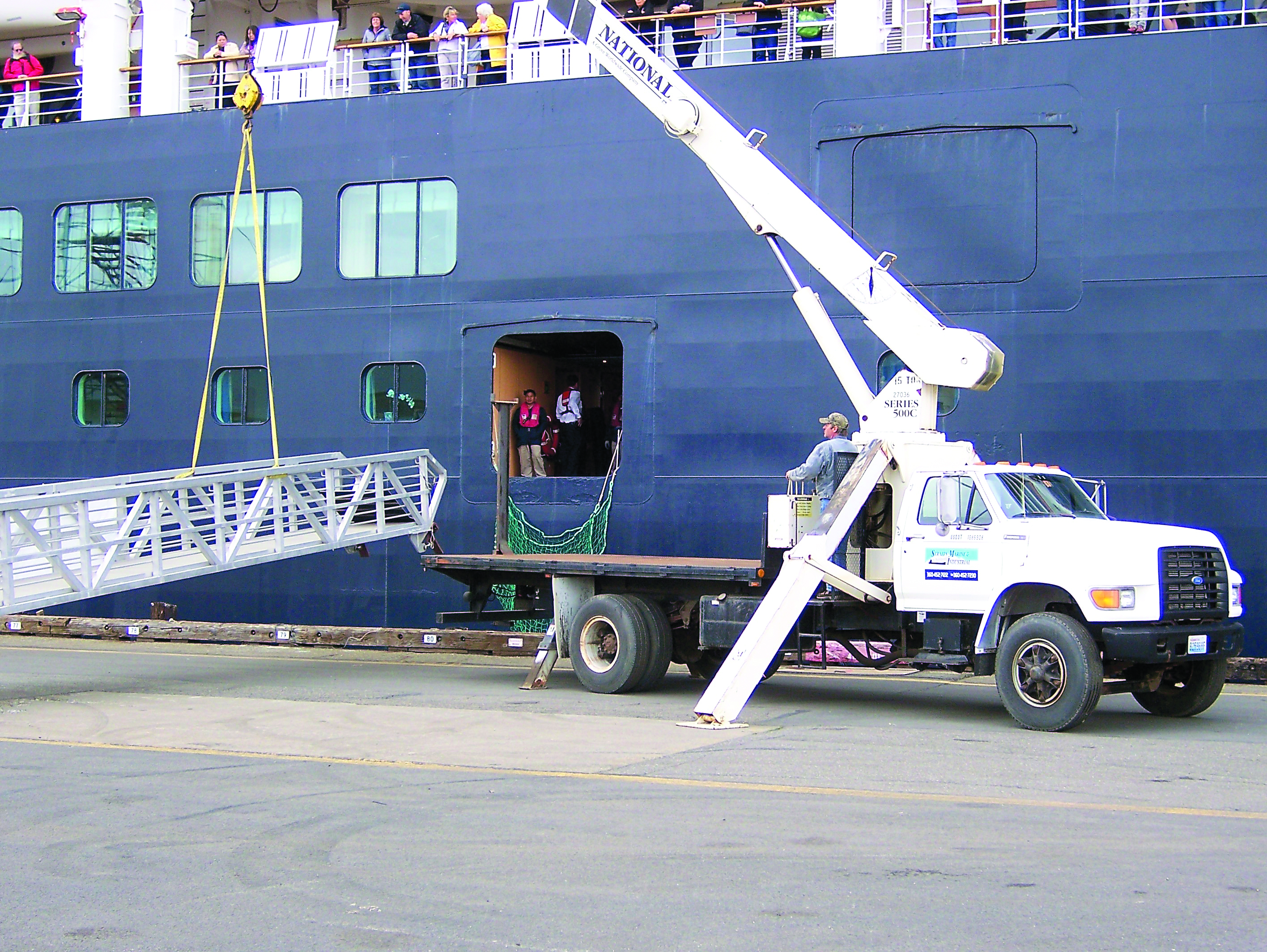 Boom truck operator Mike Boogaard of Straits Marine & Industrial of Port Angeles maneuvers the gangway to the ms Oosterdam at the Port of Port Angeles’ Terminal 1 North on Wednesday.  -- Photo by David G. Sellars/for Peninsula Daily News