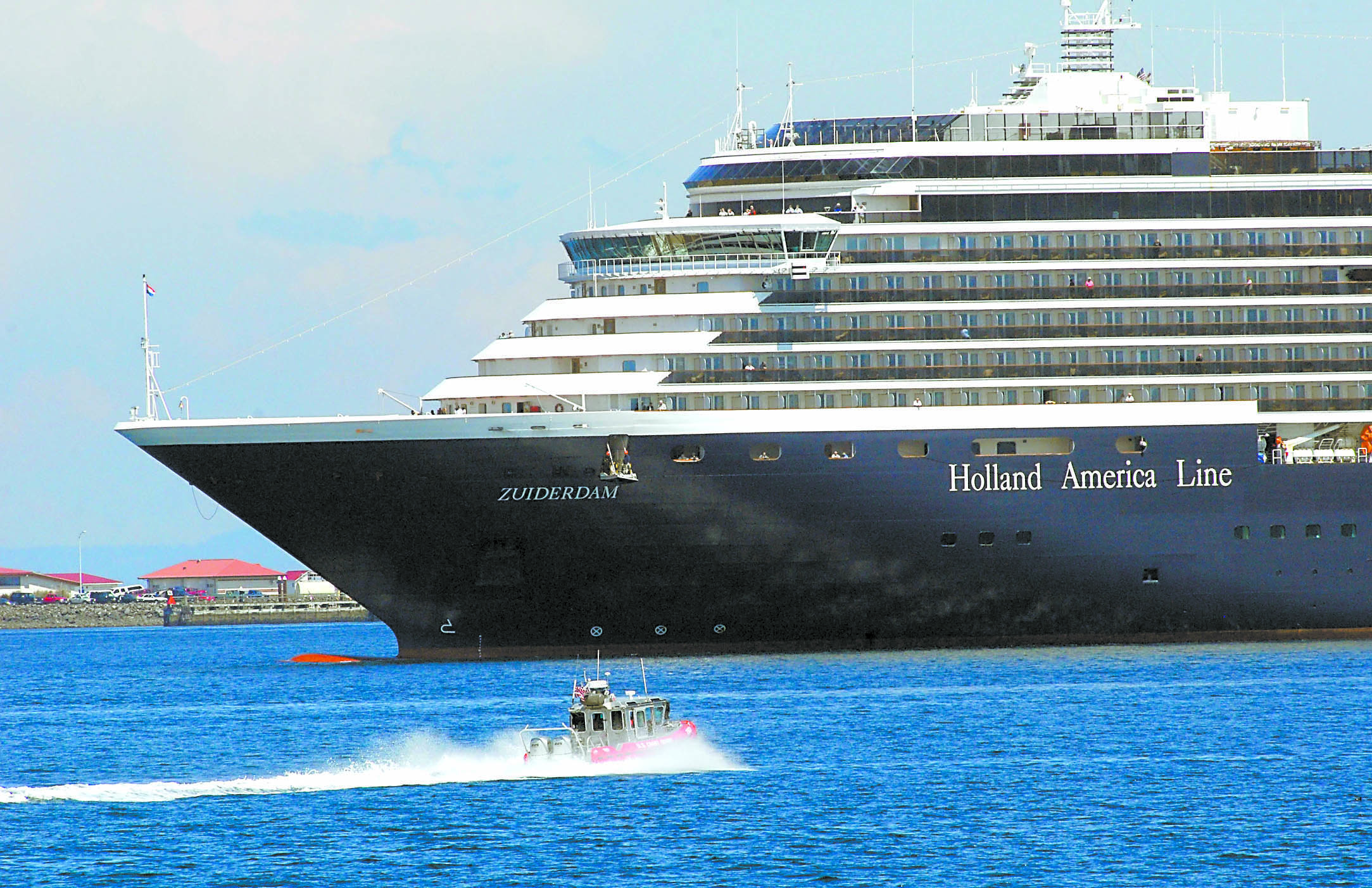 A U.S. Coast Guard patrol boat meets the Holland America Line cruise ship ms Zuiderdam as it arrives in Port Angeles Harbor on May 7