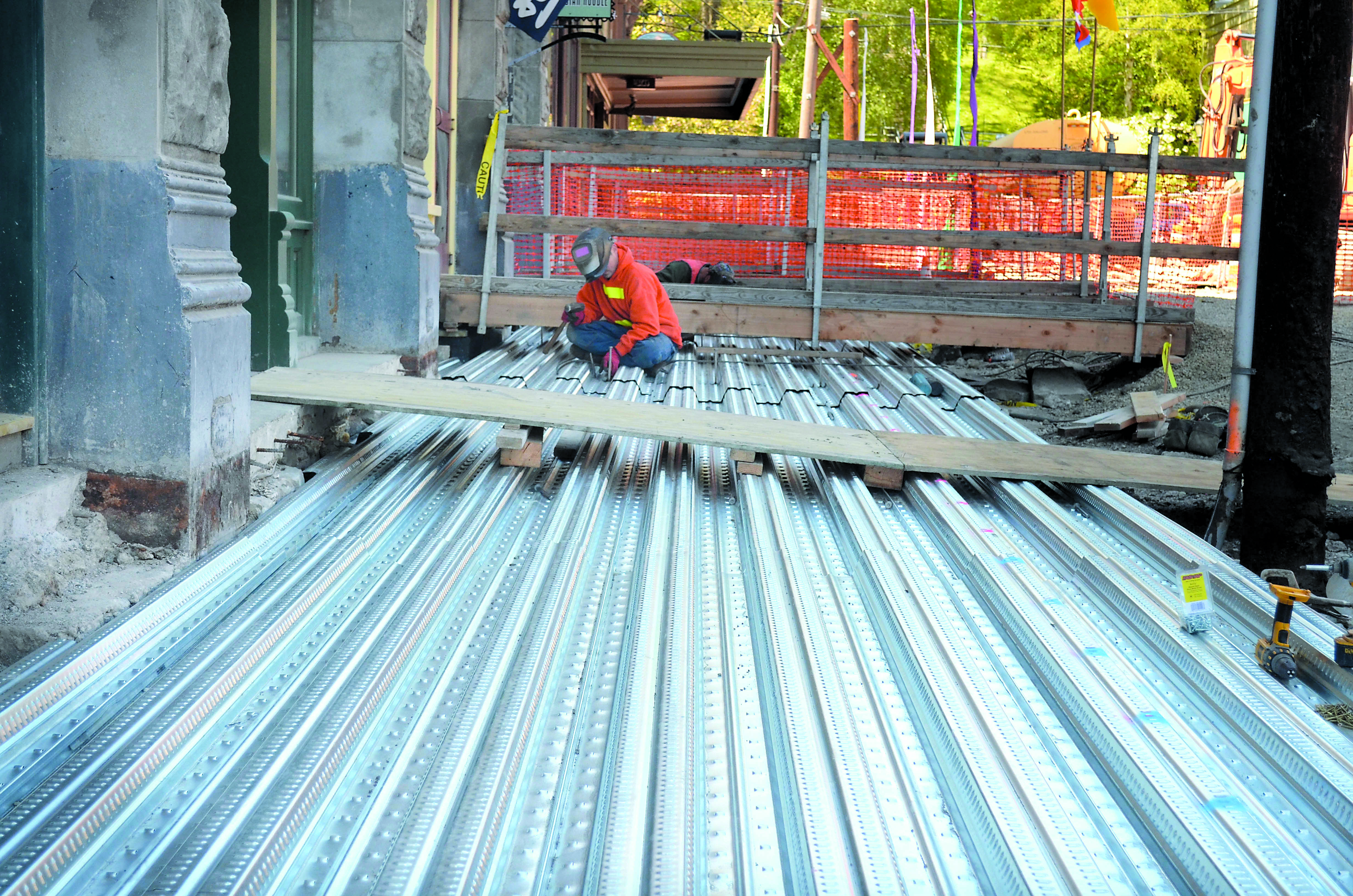 A worker welds together sections of steel that will support the new sidewalk on Taylor Street.  -- Photo by Charlie Bermant/Peninsula Daily News