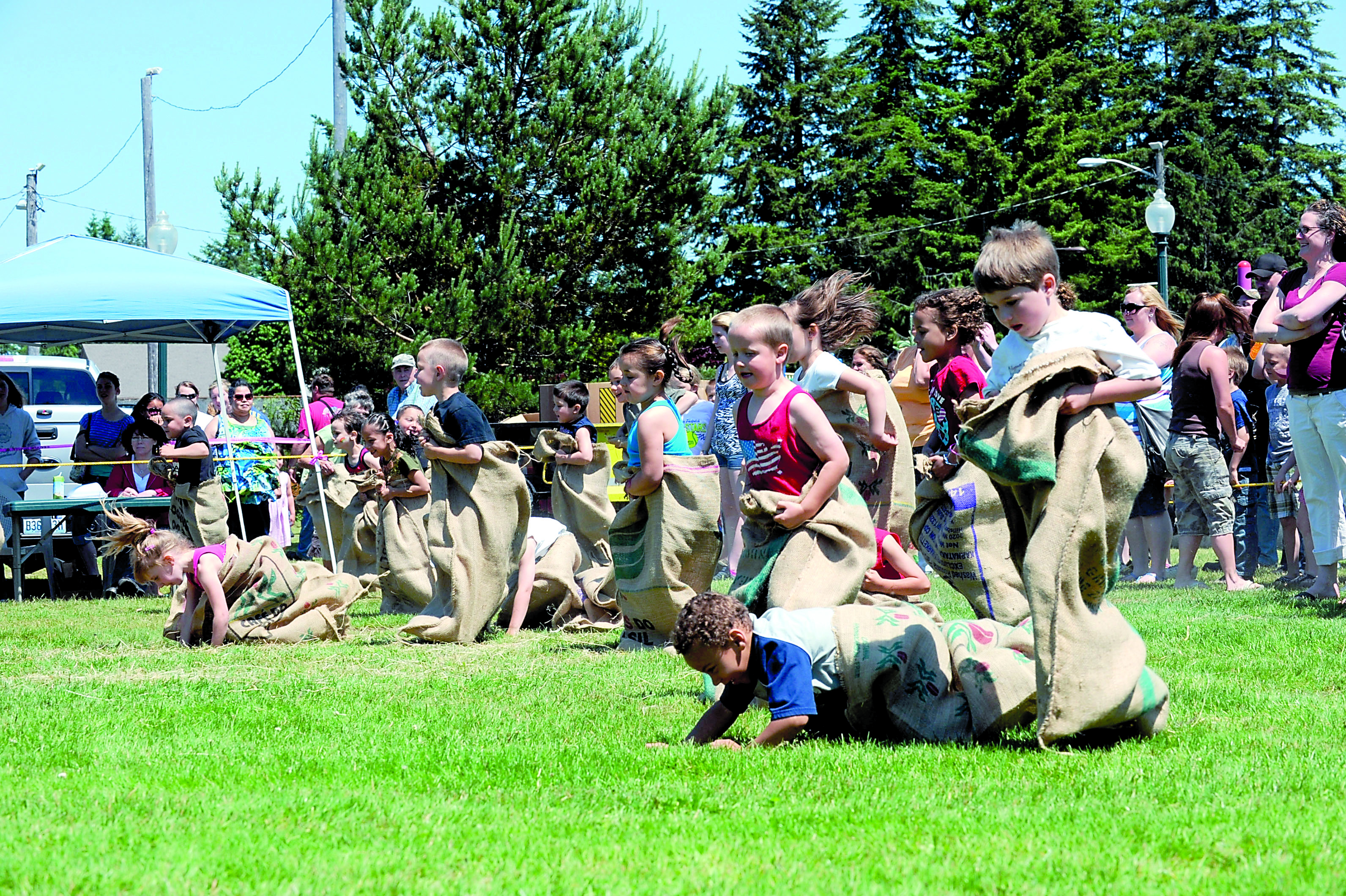 Children hop across the grass in Tillicum Park in Forks during the gunny sack races in the Old-Fashioned Fourth in 2011. Lonnie Archibald/for Peninsula Daily News