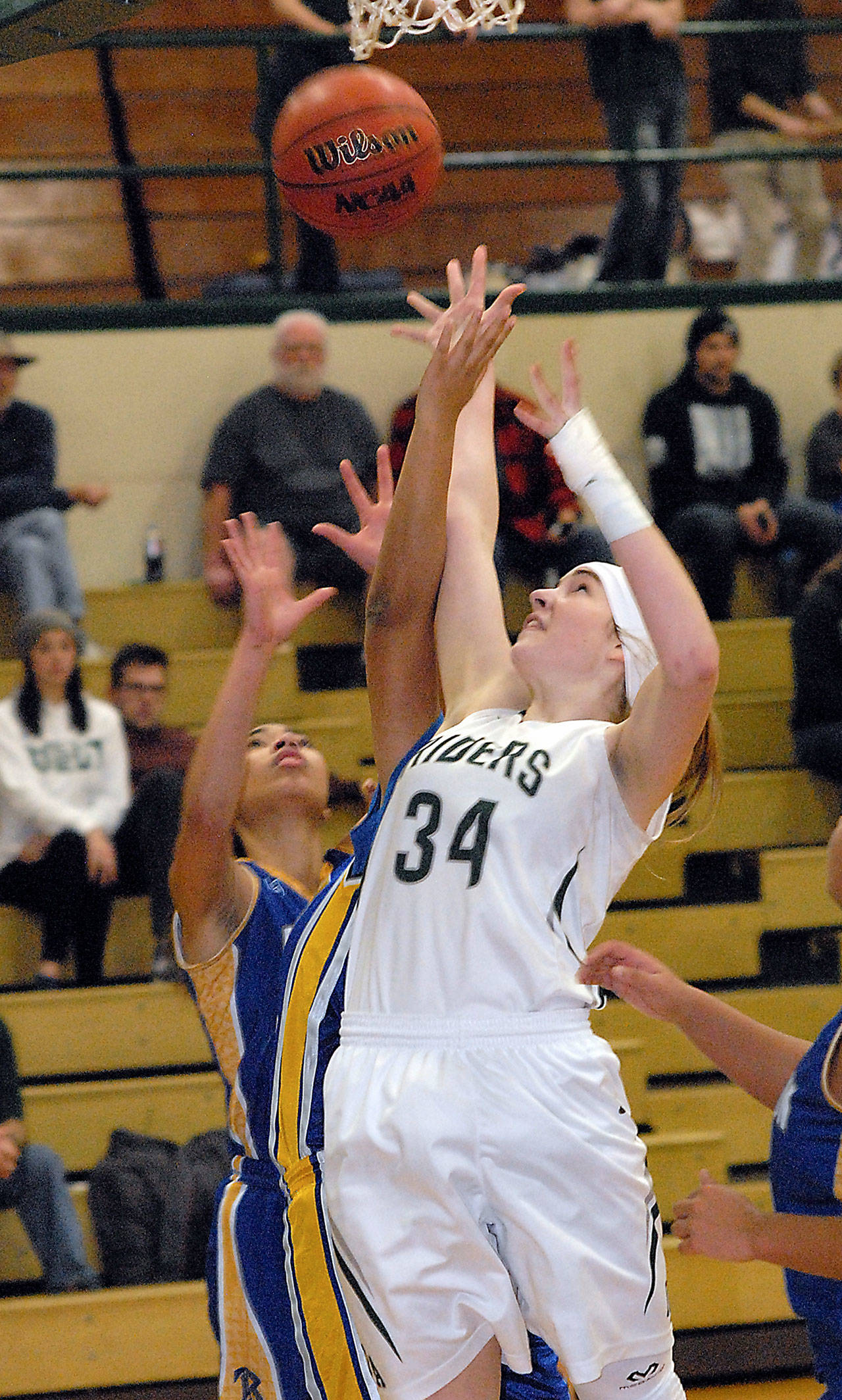 Keith Thorpe/Peninsula Daily News Port Angeles’ Devin Edwards, front, goes for a layup over Bremerton’s Carina Green, left, and Alyviah Stewart in the second quarter on Wednesday at Port Angeles High School.