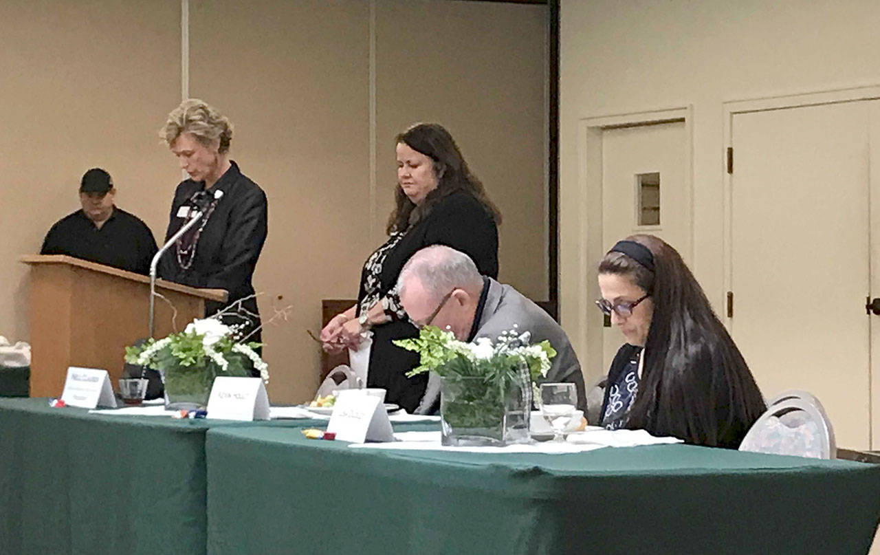 Past Sequim-Dungeness Valley Chamber of Commerce president Nell Clausen, left, Executive Director Shelli Robb-Kahler, Kevin Hoult of the North Peninsula Small Business Development Council and Lisa Dudley observe a moment of silence for retired employee Jeri Smith on Tuesday at the chamber luncheon. (Erin Hawkins/Olympic Peninsula News Group)