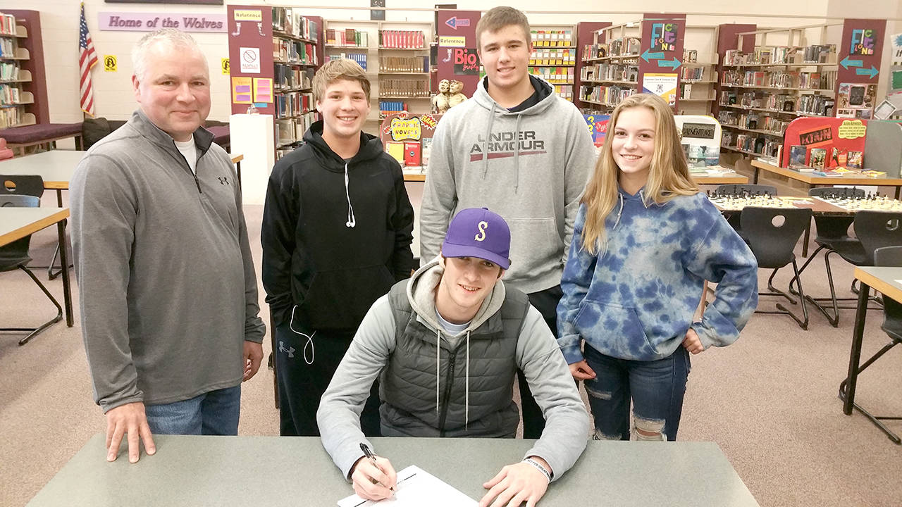 Sequim High School Sequim senior pitcher Ian Miller signs his letter of intent to play baseball at Yakima Valley Community College in Yakima. Joining Miller at the signing ceremony are, back row, from left: his father Kevin Miller, teammates Kyler Rollness and Johnnie Young and his sister Kori. Miller was a first-team All-Olympic League selection last season after posting a 5-1 record and 2.60 ERA.